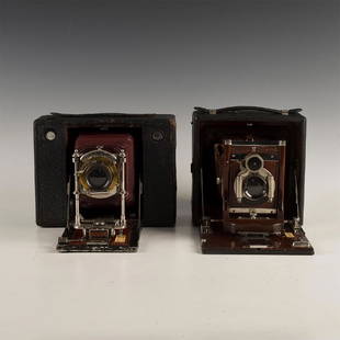 PAIR OF ANTIQUE KODAK FOLDING CAMERAS: A decorative pair from the Kodak company. Camera made from mahogany wood and cordovan leather. The hardware is made with brass and chrome. Issued: Early 20th c. Dimensions: 10"H x 6.5"L x 7"D 