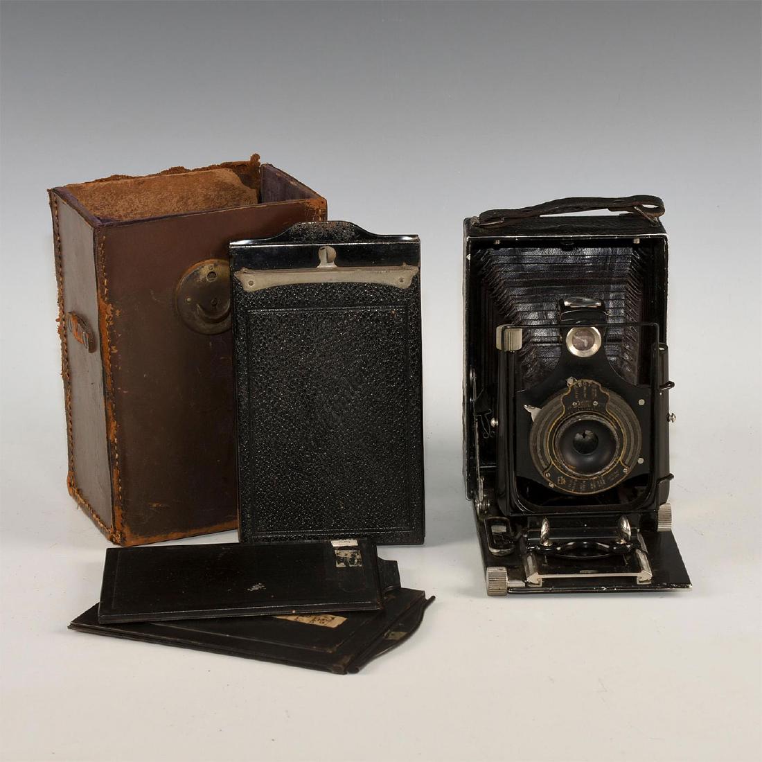 VOIGTLANDER CAMERA, 2 PLATE HOLDERS, 1 SHEET PACK: Voigtlander folding camera with Kodak ball bearing Shutter. Plate holders and sheet pack with leather case. Issued: Early 20th c. Dimensions: 7.75"L, x 6.25"H x 4.5"D Manufacturer: Various Country of