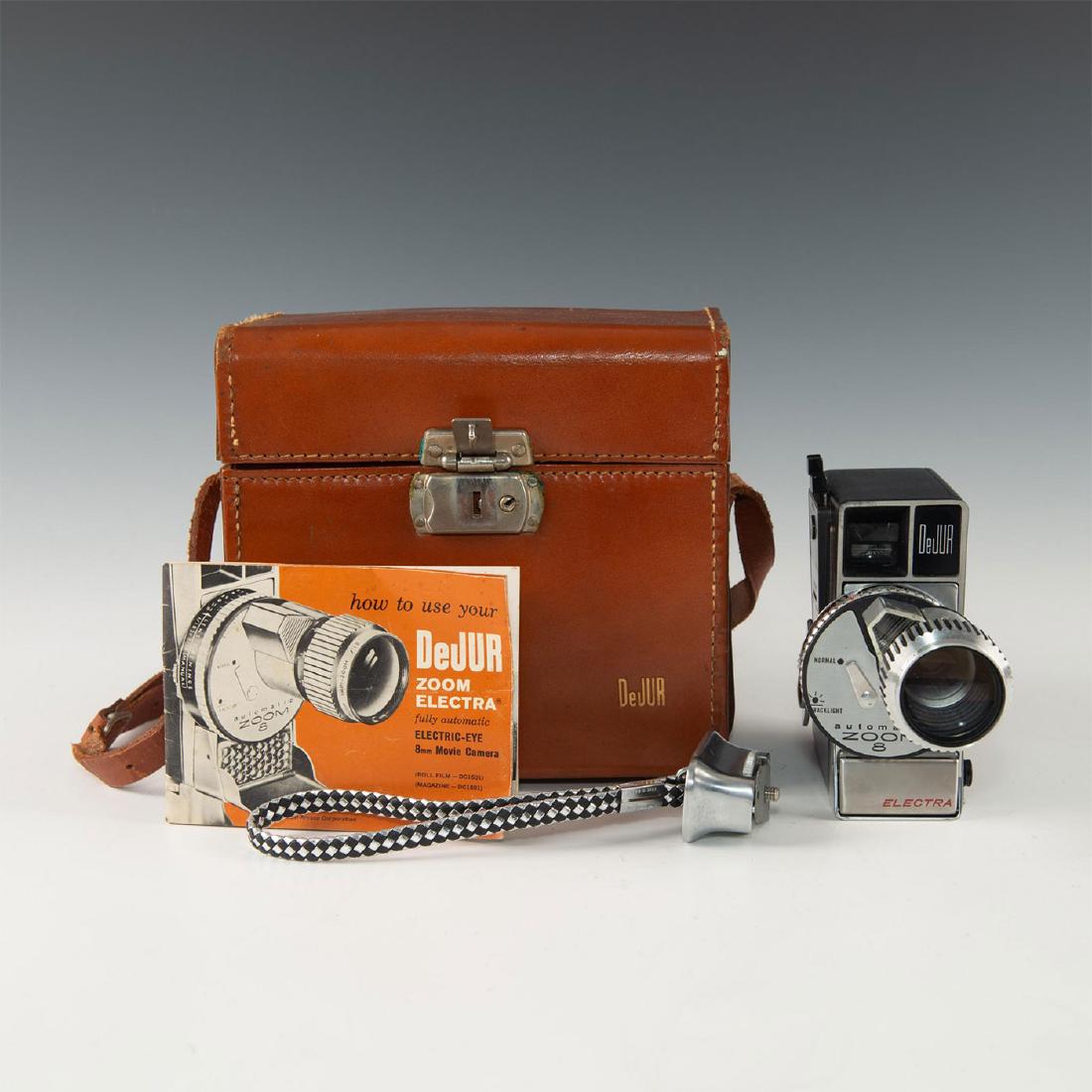 RETRO 1950'S DEJUR CLOCKWORK AUTOZOOM 8MM CINE CAMERA: Case, stap/handle, manual- clever zoom keys and classic look. Issued: 20th c. Dimensions: 8"L x 5.5"D x 7.5"H, in case Manufacturer: DeJur
