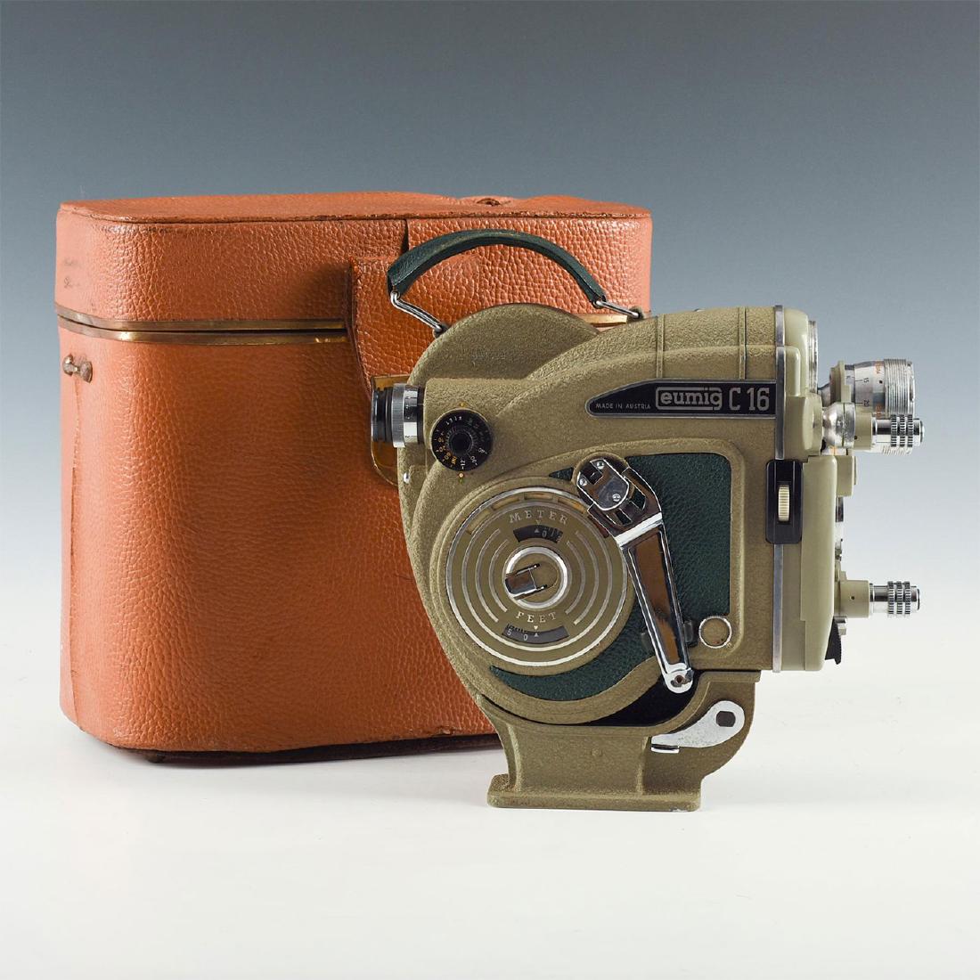 RARE EUMIG C16 CLOCKWORK 16MM CINEMA CAMERA, LENSE: Running cine camera with lens in hard case. Handle included. Issued: 1960s Dimensions: 10"L x 5.25"D x 9.75"H, in case Manufacturer: Eumig Country of Origin: Austria