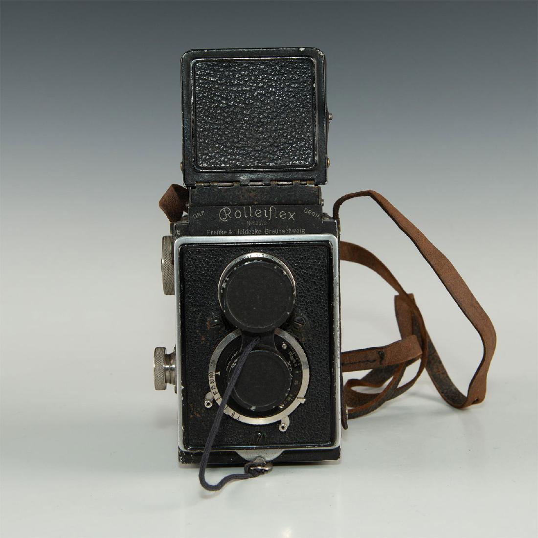 ROLLEI ROLLEIFLEX TLR CAMERA: Medium format twin-lens reflex camera with leather strap. Camera in black leatherette covering with chrome controls. It has viewfinder intact and an item no. 53572. Issued: 1929 Dimensions: 7.75"H x 3