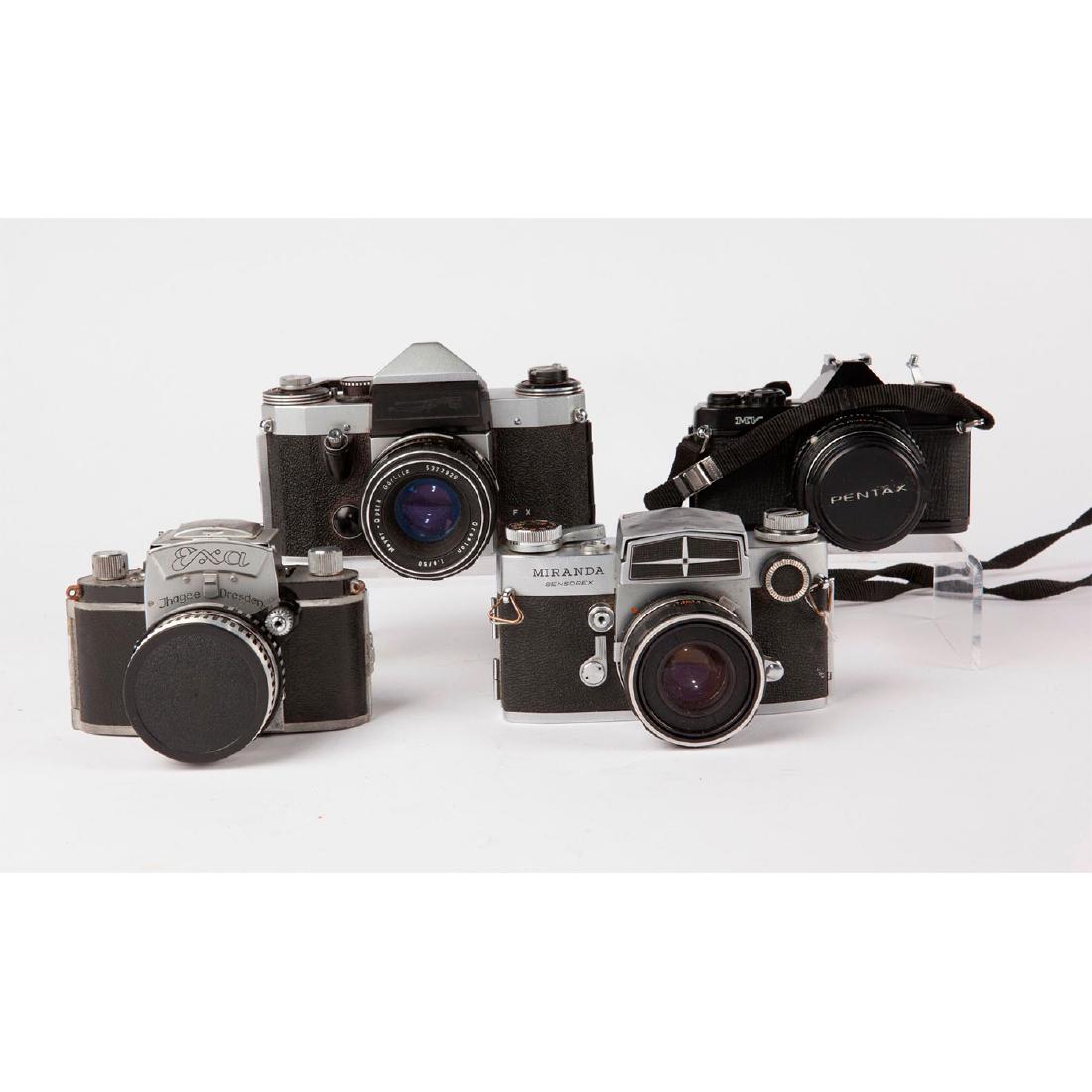 GROUP OF 4 VINTAGE MID CENTURY 35MM SLR CAMERAS: Miranda Sensorex, Asahi Pentax MV, Ihagee Exa, East German SLR East German camera is missing its badge, but is likely an Ihagee or Pentacon model. Issued: Mid 20th c. Dimensions: 4"H x 6"L x 3.75"D Ma