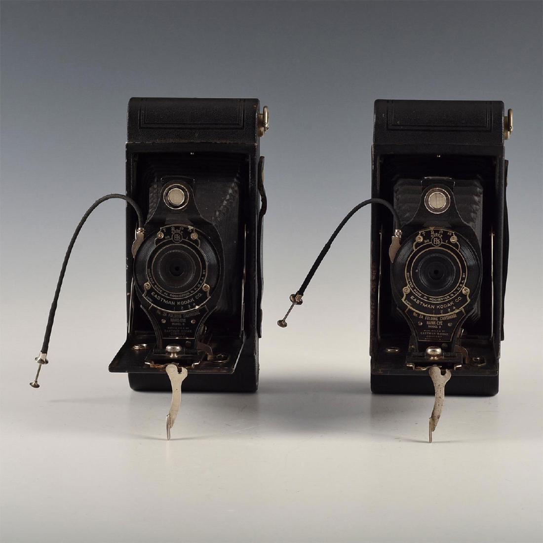 MATCH SET PAIR OF ANTIQUE FOLDING KODAK CAMERAS: Ideal bookend pair of No. 2 Hawkeye model Bs with remote cables. Issued: 1900s Dimensions: 6"L x 3.5"D x 8"H Manufacturer: Kodak Country of Origin: United States