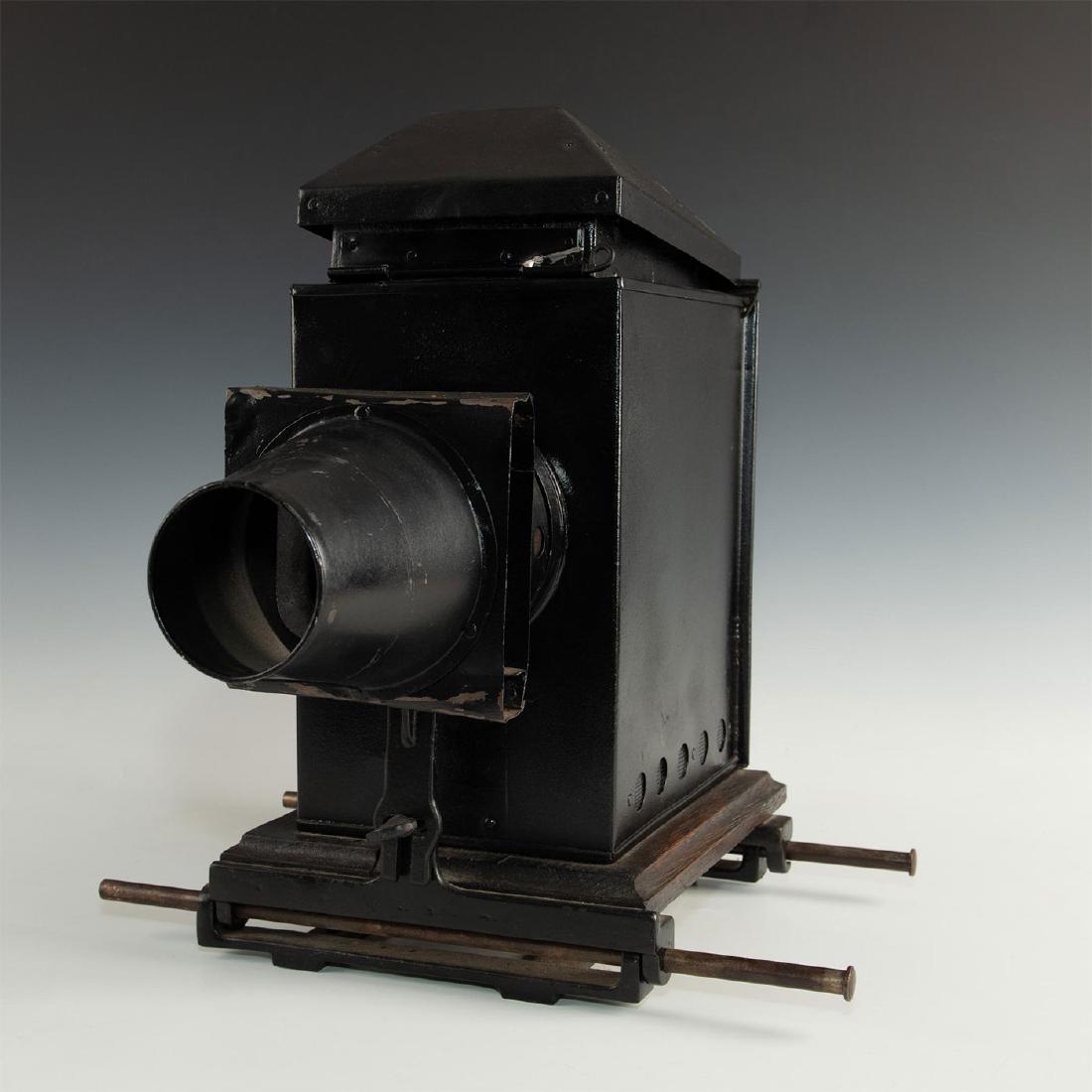 STEREOPTICON MAGIC LANTERN SLIDE PROJECTOR: Large stereopticon, heavy cast metal cabinet, and cast aluminum. Mounted on a wooden base with metal brackets attached. Issued: c. 1880 Dimensions: 17.5"H x 17.5"L