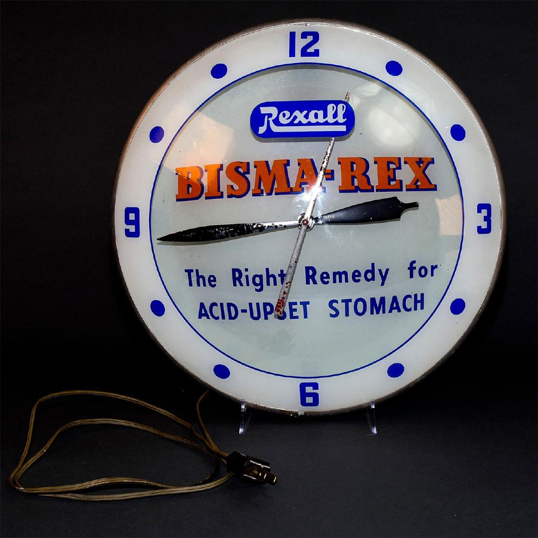 VINTAGE DOUBLE BUBBLE ADVERTISING CLOCK, REXALL: Two internal light fixtures, advertising for iconic drugstore. Double glass. Lighting sockets tested, working. Motor and time mechanics untested. Issued: 1950s Dimensions: 16"D x 1.75"H Manufacturer: