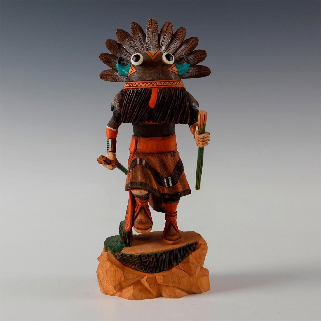 NATIVE AMERICAN HOPI BROAD FACE KACHINA DOLL: Carved wooden Katsina Kachina doll. Doll is depicted with feathered headdress and horns; it carries whips in hands. Figure is also known as Wuyak-kuita or the whipper. The whippers played an important