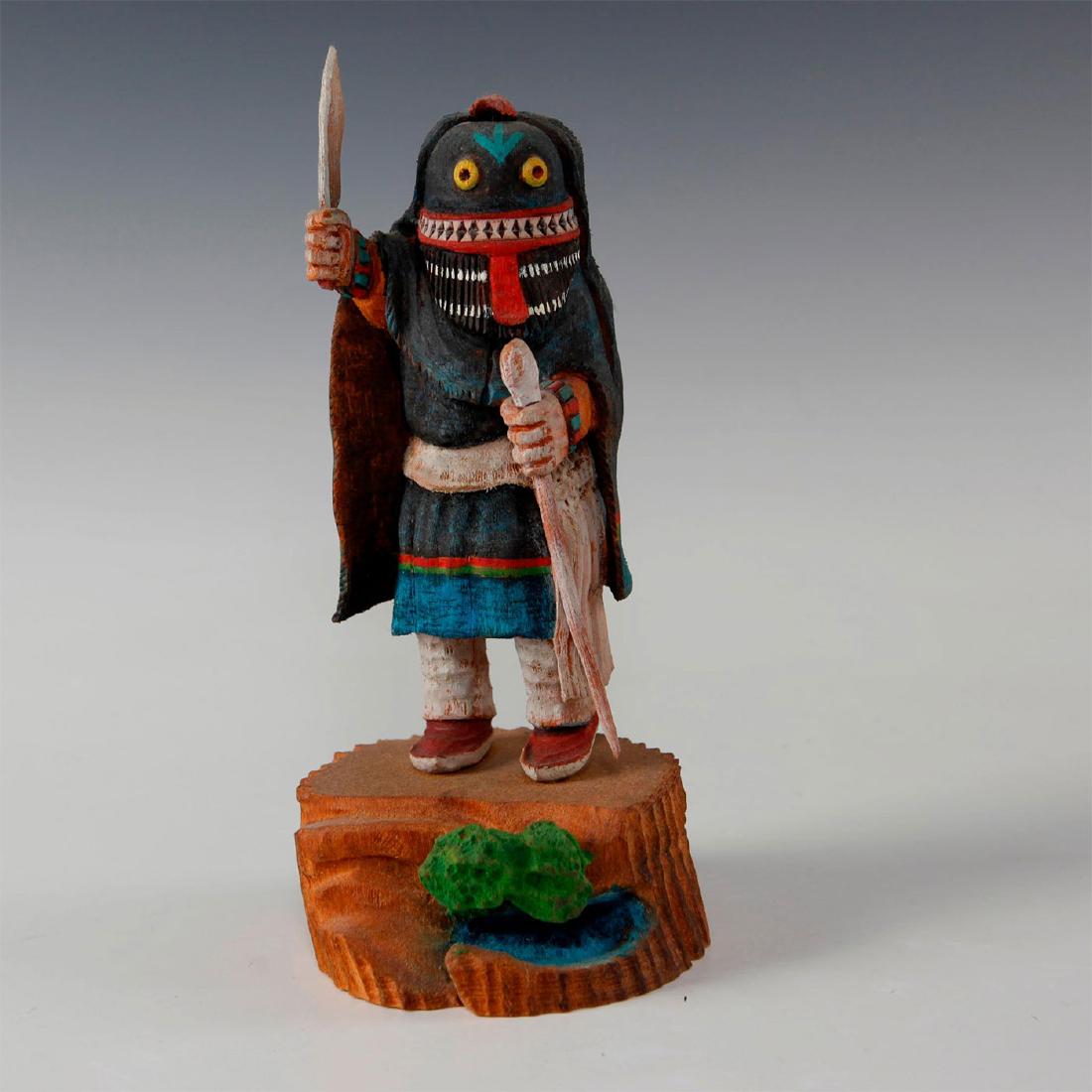 NATIVE AMERICAN HOPI SOYOKO WUHTI KACHINA DOLL: Carved wooden figure of an Ogre Woman. The figure depicts a woman with long hair and she carries a knife and a long crook. The Ogre women is known as the disciplinarian of the tribe and strikes fear i