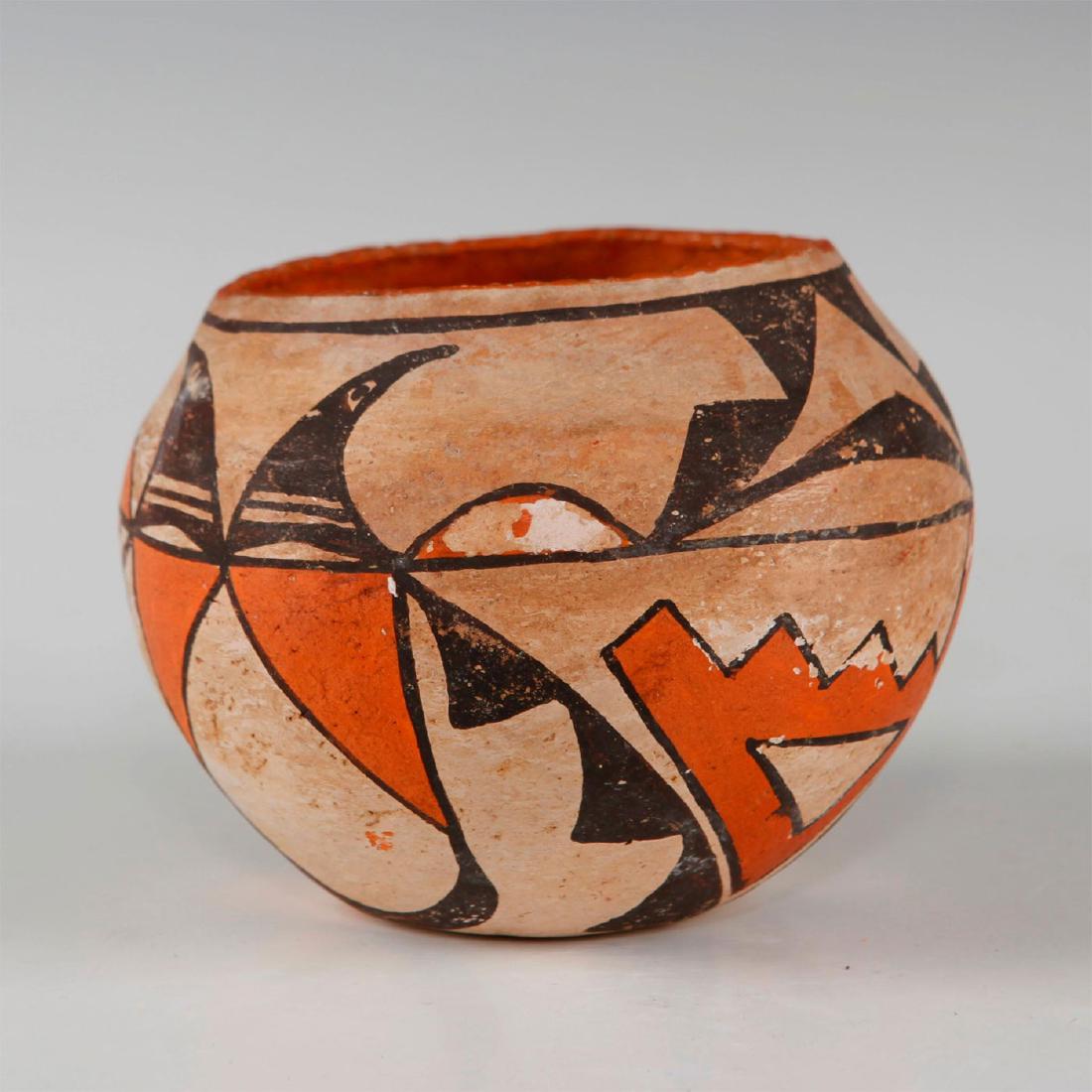 NATIVE AMERICAN SMALL ANTIQUE ACOMA OLLA: Ceramic bowl from the Acoma Pueblo tribe. White slip vessel with traditionalist polychrome glyph decoration, and textured rim. Marked on the bottom ACOMA. Some surface ablation, common to this type of