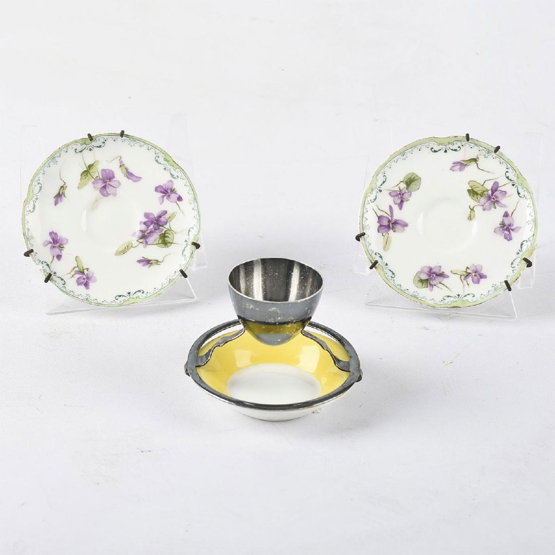 MAPPIN & WEBB EGG CUP WITH UNDERPLATE AND TWO SAUCERS: By Royal Doulton and Mappin & Webb Ltd. Includes a silver plated egg cup by Mappin and Webb with a yellow underplate by Royal Doulton. Complete with a pair of Royal Doulton demitasse saucers. Doulton