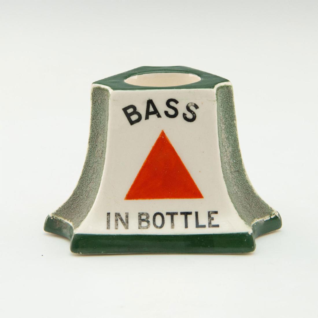 ROYAL DOULTON BASS IN BOTTLE BAR MATCH STRIKER: Doulton advertising match striker for the company Bass Brewery. Figure is green and white with black lettering and also pictures a red triangle. Doulton backstamp. Issued: 1906-1922 Dimensions: 3"H x 