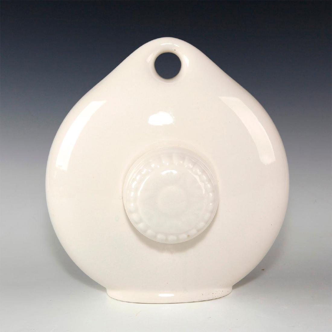 ROYAL DOULTON PORCELAIN BED WARMER: Ceramic hot water bottle with screw top and white finish. Issued: Early 20th c. Dimensions: 9"L x 8.25"W Manufacturer: Royal Doulton Provenance: Diane Alexander collection Country of Origin: England