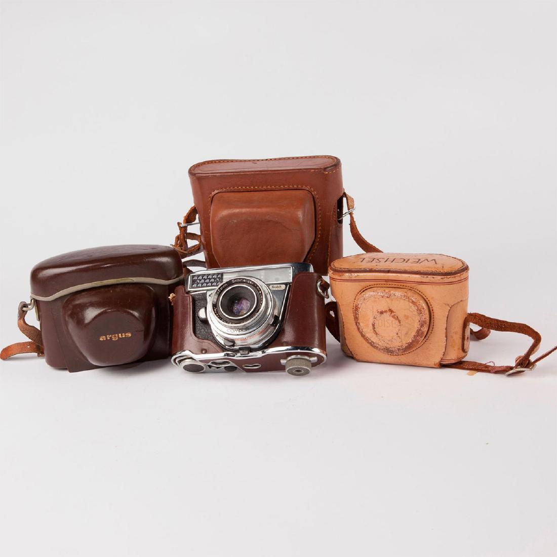 GROUP OF FOUR VINTAGE RETRO RANGEFINDERS: Four decorative American cameras in leather cases. Kodak 35, Bosley B 22 Set-o-matic , Argus v-100, Retina IIF. Issued: Mid 20th c. Dimensions: 4.25"H X 6"L X 4"D, largest Manufacturer: Various Countr