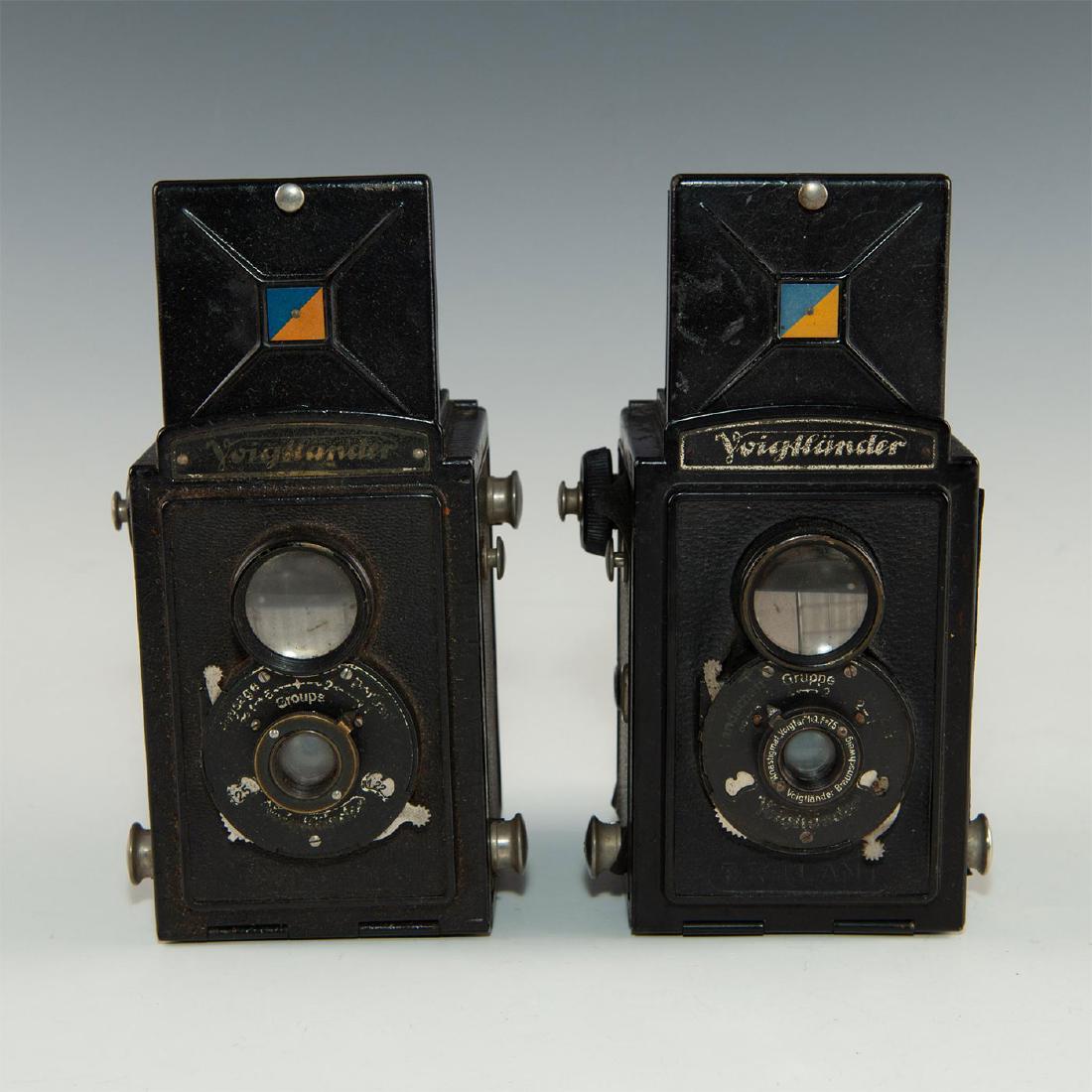 PAIR OF VINTAGE GERMAN VOIGTLANDER TLR CAMERAS: Decorative set of black roll film cameras. Issued: Early 20th c. Dimensions: 6.5" H X 3" L X 2.75" D, tallest Manufacturer: Voigtlander Country of Origin: Germany