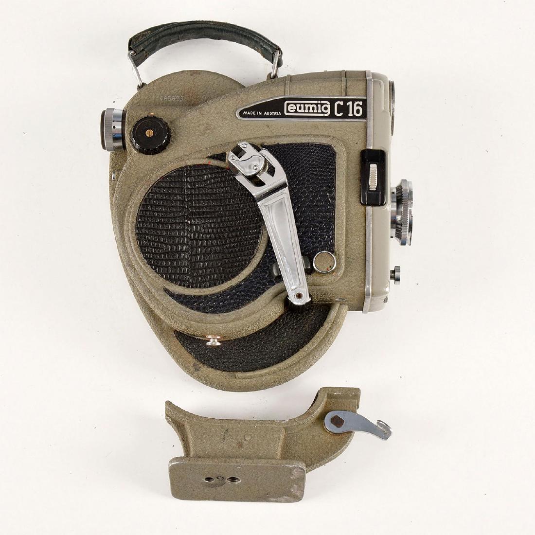 VINTAGE AUSTRIAN EUMIG C 16 MOTION PICTURE CAMERA: Leatherette to exterior. Working motor. Green leather strap. 16 mm handheld film camera introduced in 1956 and manufactured at the companys then-state of the art factory complex at Wiener Neudorf (Aus