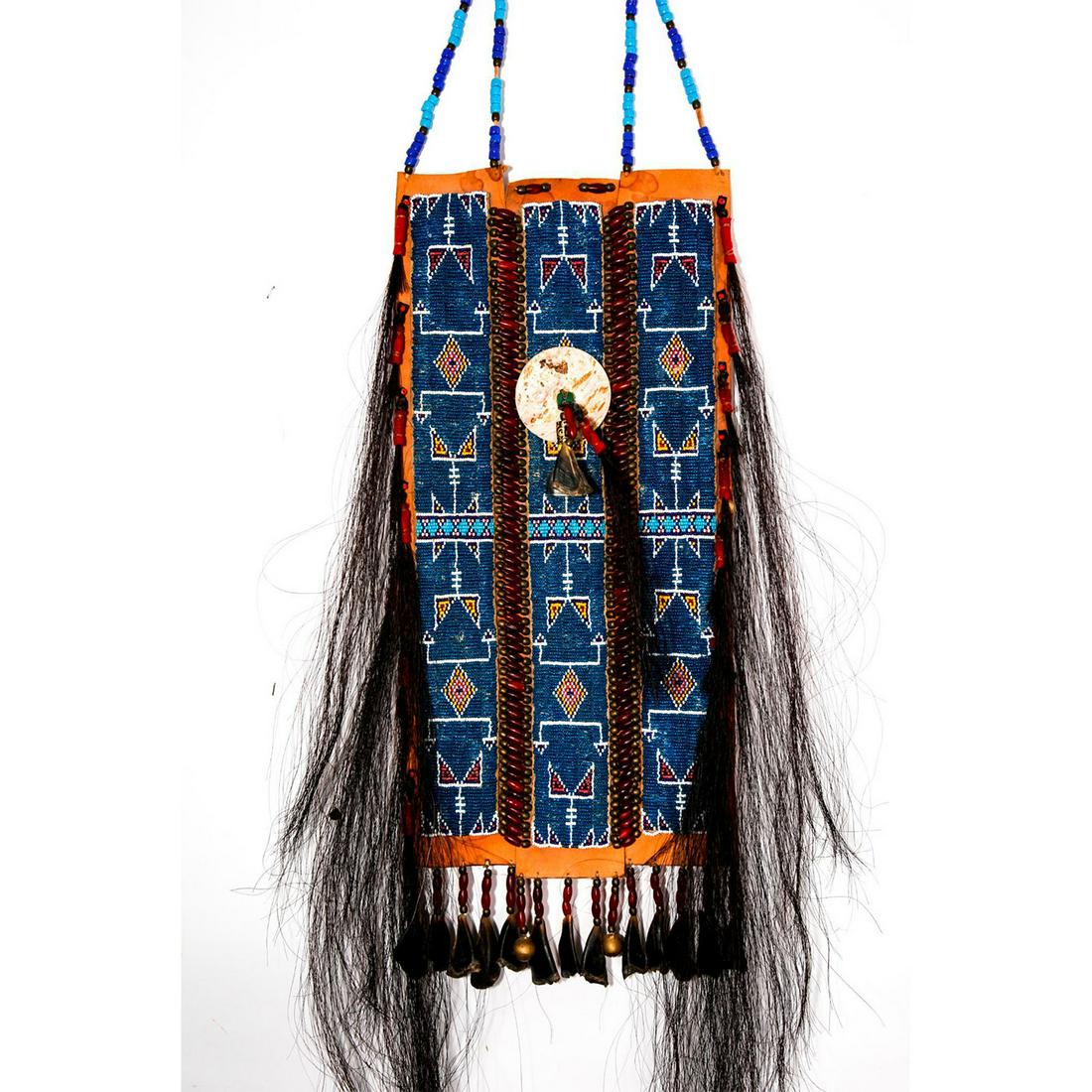 NATIVE AMERICAN TRIBAL LEATHER BREASTPLATE ARMOR: Reproduction ceremonial decorative and medicinal armor. Formed by three hardened tanned rectangular leather pieces, decorated with carved horn, bells, horsehair fringe trim, and colorful beads. Tradit