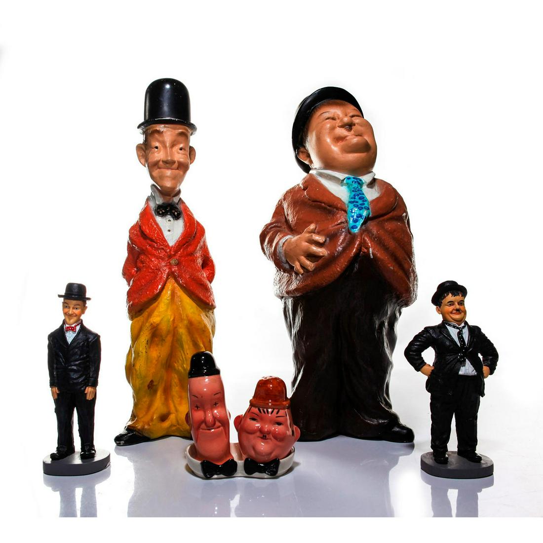 LAUREL AND HARDY FIGURINES, STATUES AND SALT SHAKER SET: Six items plus salt and pepper shaker base. Marked to bases. Six collectible items commemorating the comedy team of Stan Laurel and Oliver Hardy: Two Universal Studios large resin cartoon statues, pro