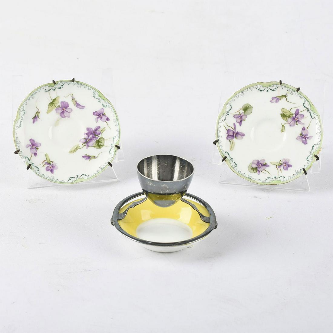MAPPIN & WEBB EGG CUP WITH UNDERPLATE AND TWO SAUCERS: By Royal Doulton and Mappin & Webb Ltd. Includes a silver plated egg cup by Mappin and Webb with a yellow underplate by Royal Doulton. Complete with a pair of Royal Doulton demitasse saucers. Doulton