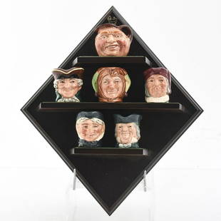 6 TINY ROYAL DOULTON CHARACTER JUGS AND WALL STAND: Simon Cellarer, D.Turpin, P. Brown, Granny, J. Barleycorn, Jester. Wallstand made of wood Artist: William Harper, Simon Ward Issued: 20th c. Dimensions: 10"H, wall stand Manufacturer: Royal