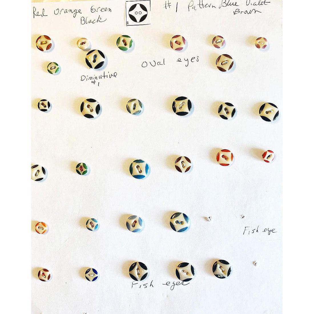 5 CARDS OF CHINA STENCIL BUTTONS: Over 100 China Stencil buttons. All in various colors and patterns. Included are several squares also in a variety of colors as well as a few face stencils and a scarcer fish eye body style, very cool