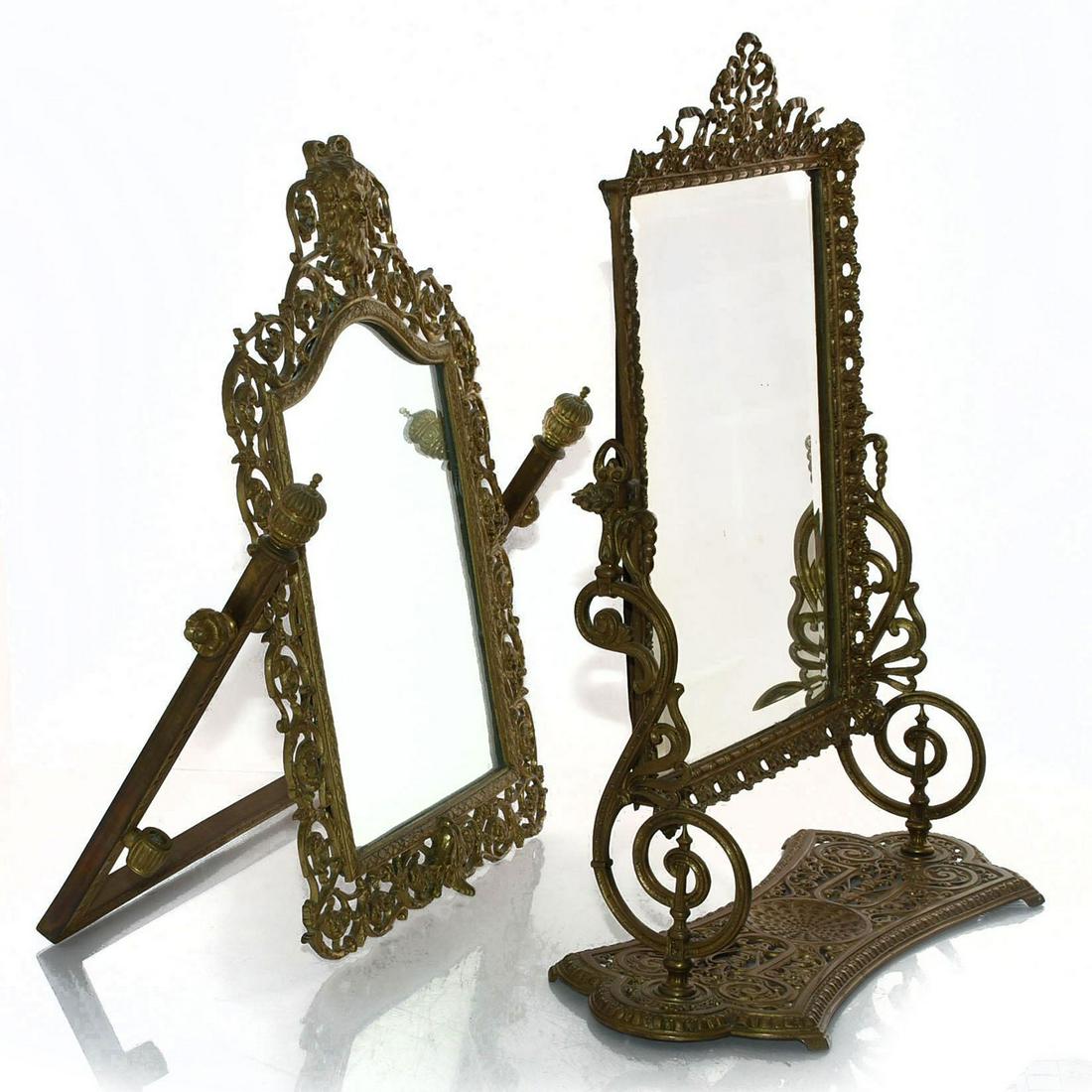 PAIR OF BRASS MIRRORS: Ornate mirrors with reticulated designs. Stand mirror has cherub and floral design. Convertible mirror has head of Bacchus on top and grape leaf design. Can be used tabletop with stand or hung on wall