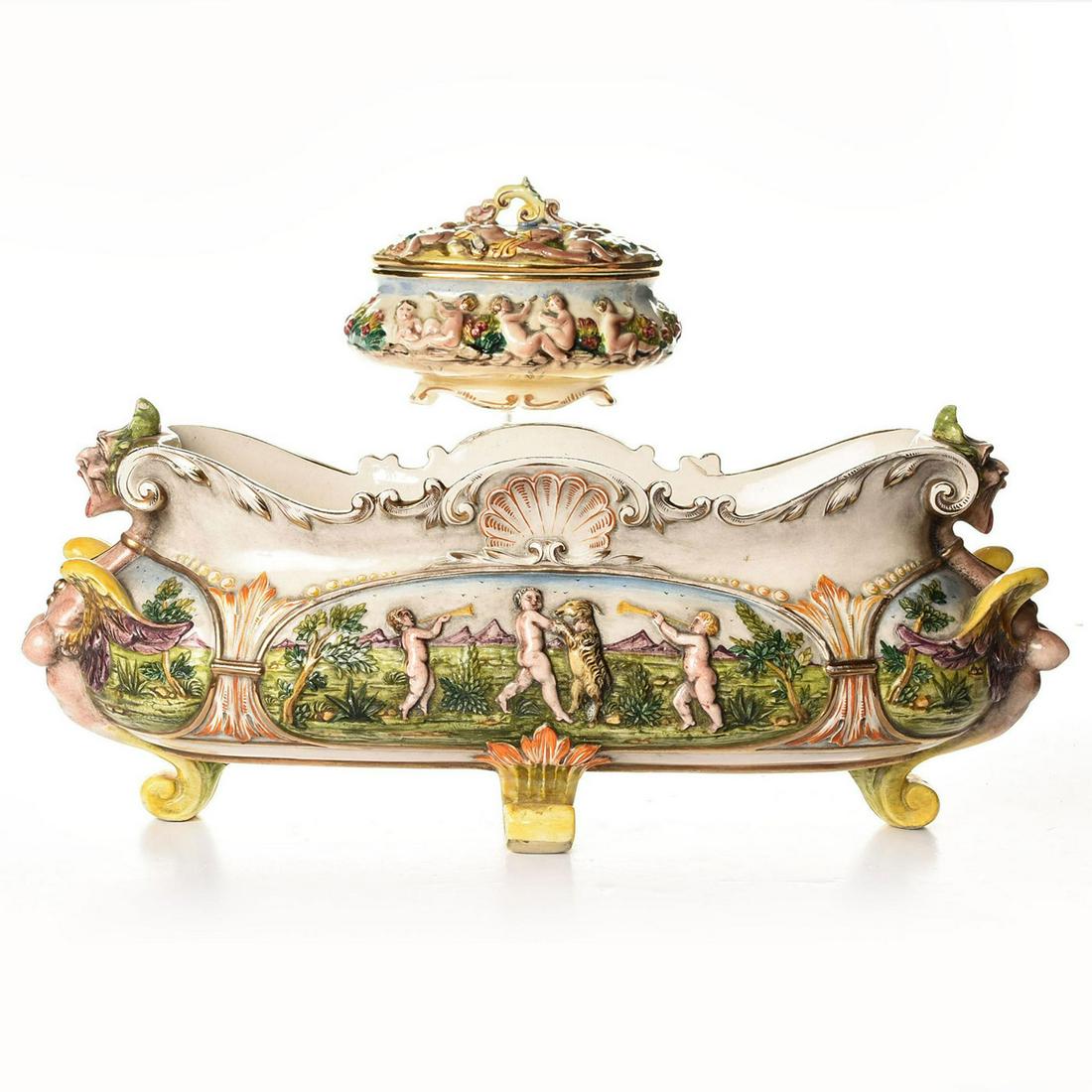 2 CAPODIMONTE, LARGE CENTERPIECE BOWL AND LIDDED JAR: Ceramic tableware with raised cherubs pattern and gilded design. All pieces marked on the underside. Issued: 19th c. Dimensions: 19"L x 7"H, largest Manufacturer: Capodimonte Country of Origin: Italy
