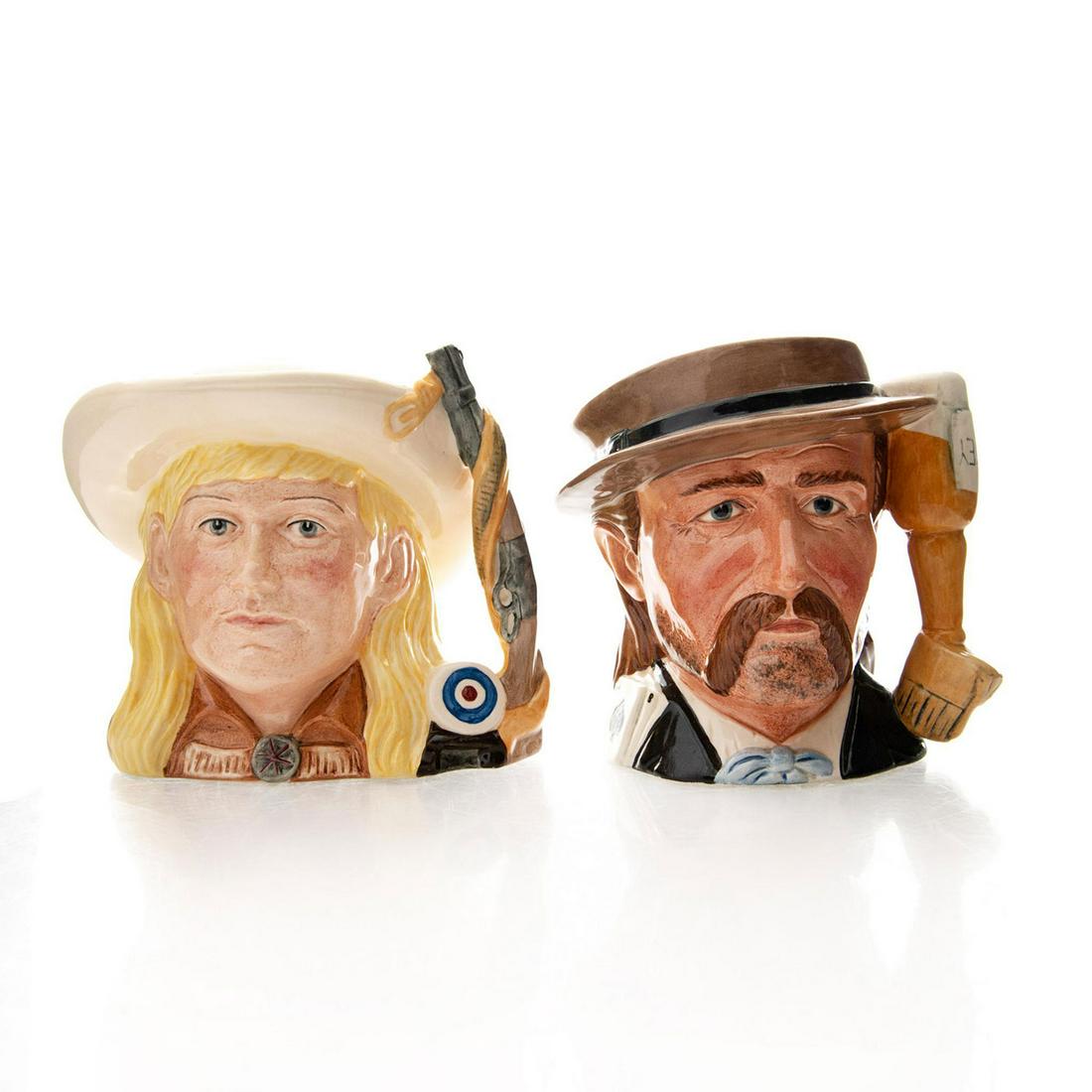 2 ROYAL DOULTON WILD WEST CHARACTER JUGS: Mid size. Wild Bill Hickock D6736 and Annie Oakley D6732. Royal Doulton backstamp. Artist: Stanley James Taylor, Michael Adderly Issued: 20th c. Dimensions: 5.75"H Manufacturer: Royal Doulton Country 