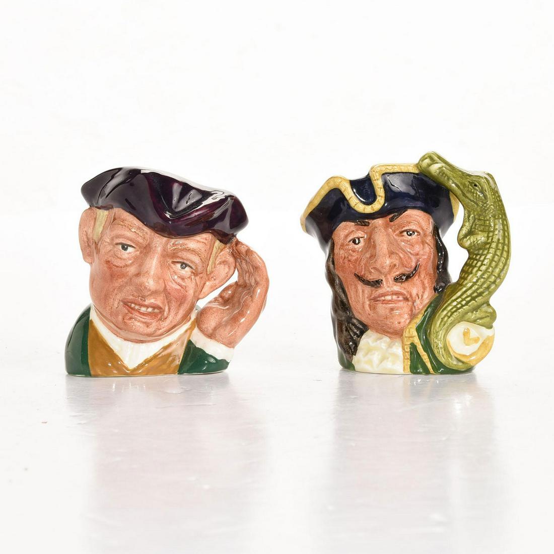 2 ROYAL DOULTON MINIATURE CHARACTER JUGS: Ard of 'Earing, hand cupped to his ear handle. Capt. Hook. Artist: David Biggs Issued: 20th c. Dimensions: 2.5"H, tallest Manufacturer: Royal Doulton Country of Origin: England
