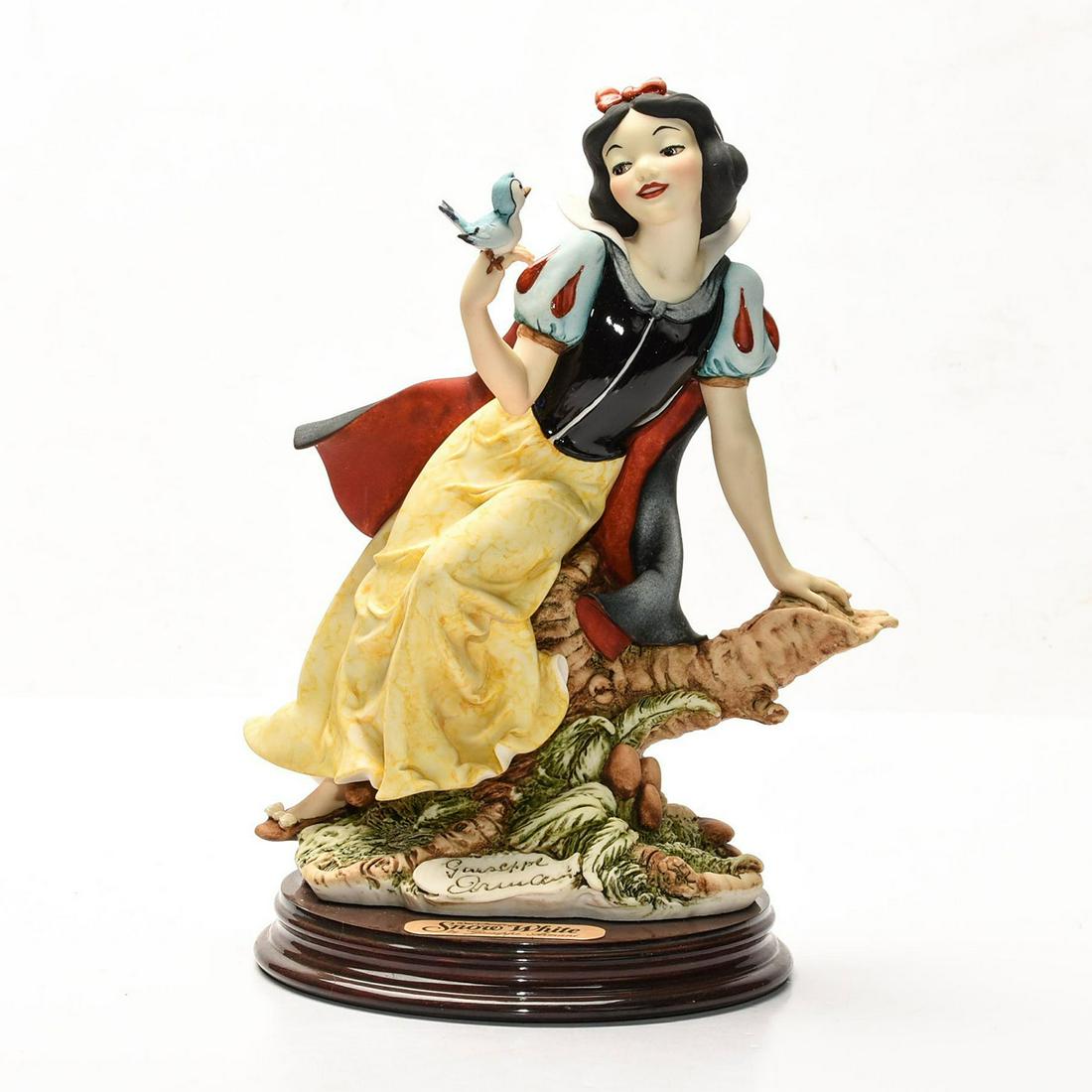 DISNEY GIUSEPPE ARMANI FIGURINE, SNOW WHITE: Artist signed, presented on decorative wooden base. DISNEY stamp. A Walt Disney special edition sculpture by Italian artist Giuseppe Armani (1935-2006) depicting an exquisitely detailed scene from the