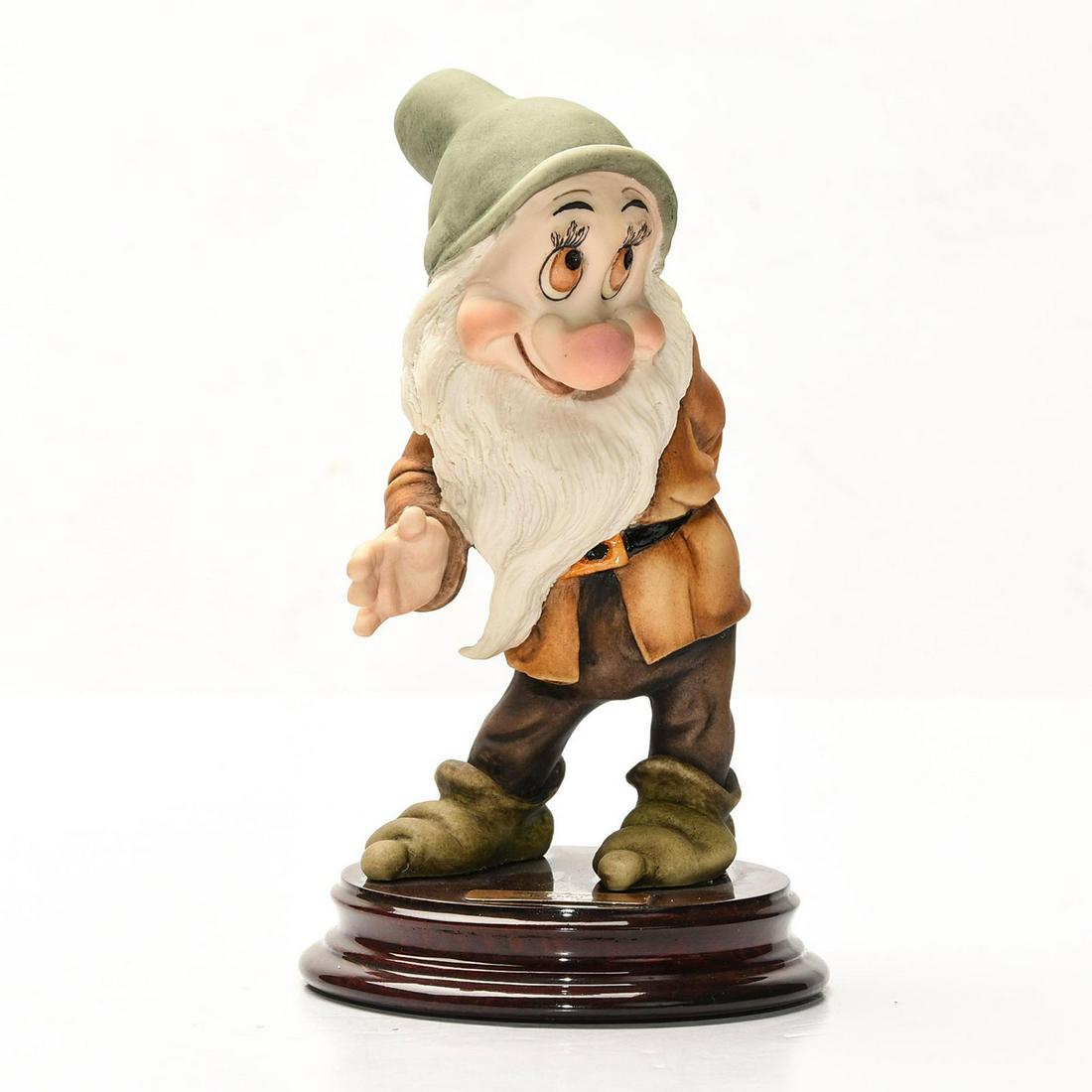 DISNEY GIUSEPPE ARMANI SNOW WHITE FIGURINE, BASHFUL: Artist signed, presented on decorative wooden base. DISNEY stamp. A Walt Disney special edition sculpture by Italian artist Giuseppe Armani (1935-2006) depicting an exquisitely detailed scene from the