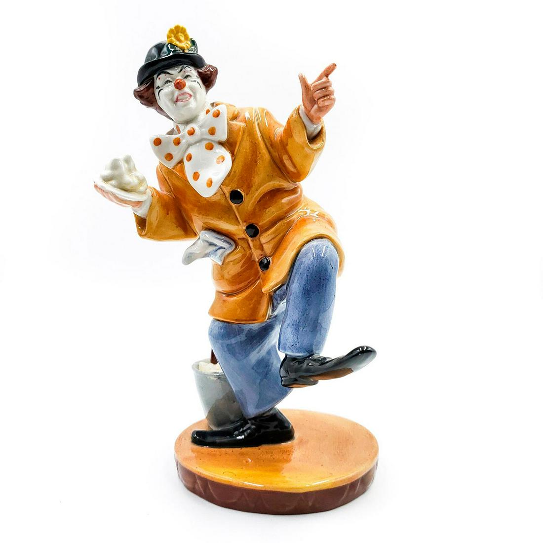 ROYAL DOULTON FIGURINE, THE CLOWN HN2890: Gold and gray. Royal Doulton stamped on underside. Artist: W.K. Harper Issued: 1979-1988 Dimensions: 9"H Manufacturer: Royal Doulton Country of Origin: England