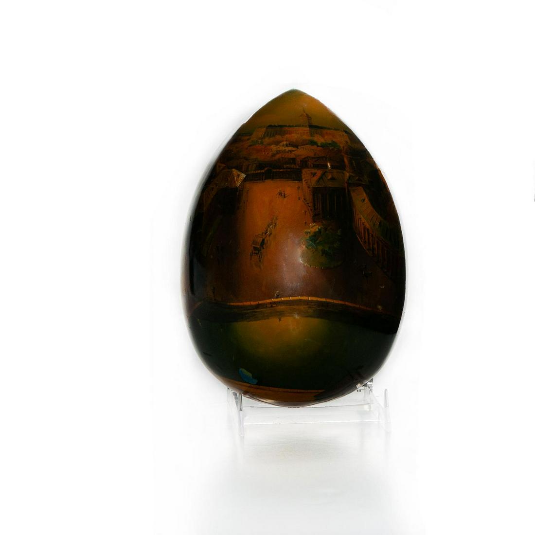 ENAMELED CERAMIC DECORATIVE EGG: Painted scene of European city. Signed and dated, bottom. Chips to enamel. Issued: 1997 Dimensions: 7.5"H