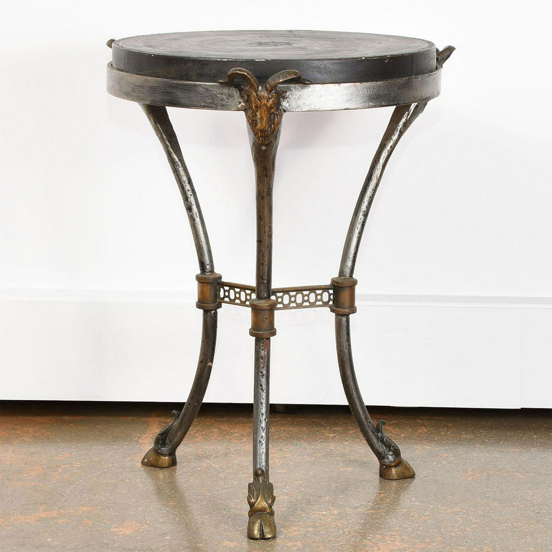 ACCENT TABLE WITH RAM HEAD AND HOOF DESIGN: Three footed metal table with patina. Wood top. Issued: 20th c. Dimensions: 22"H x 17"W