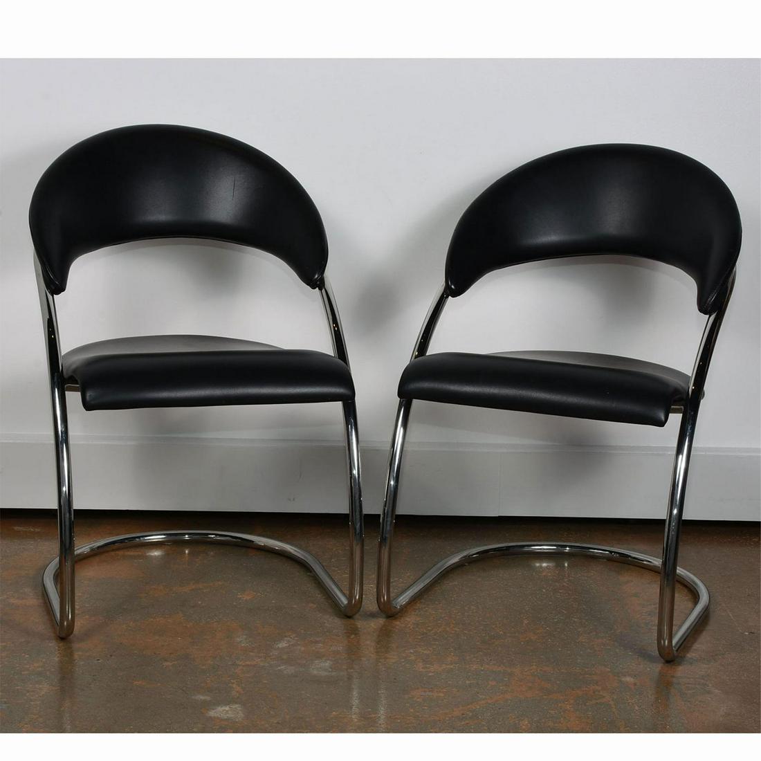 2 MID CENTURY MODERN BRUETON LUCKHARDT CHAIRS: Black faux leather on polished stainless steel. Use related wear, orange spot on leather on one chair. Issued: 20th c. Dimensions: 21"W x 34"H x 23.5"D Manufacturer: Brueton Country of Origin: United