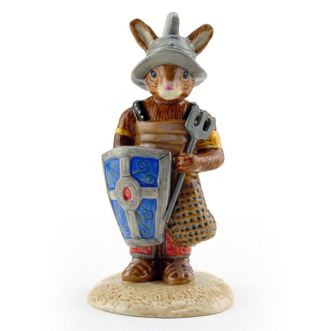 GLADIATOR BUNNYKINS DB326 - ROYAL DOULTON BUNNYKINS: Royal Doulton Bunnykins, Gladiator Bunnykins DB326 (beige, brown, blue, black, silver and yellow coloration). Issued 2004 -2005. Size 4.25"H Artist: M. Alcock Issued: 2004 - 2005 Dimensions: 4.25"H Ma
