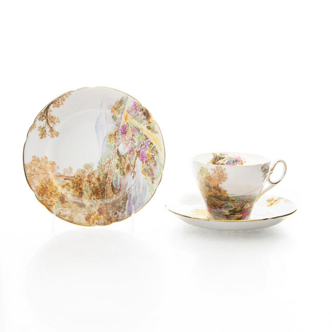 3 PC SHELLEY BONE CHINA SET, HEATHER 0187: Tea cup, saucer, dessert plate with idyllic pastoral scene, gilt. Stamped on underside with Heather "Ideal" Bone China 0187 and Shelley England Issued: 20th. c. Dimensions: 6"D, largest Manufacturer: