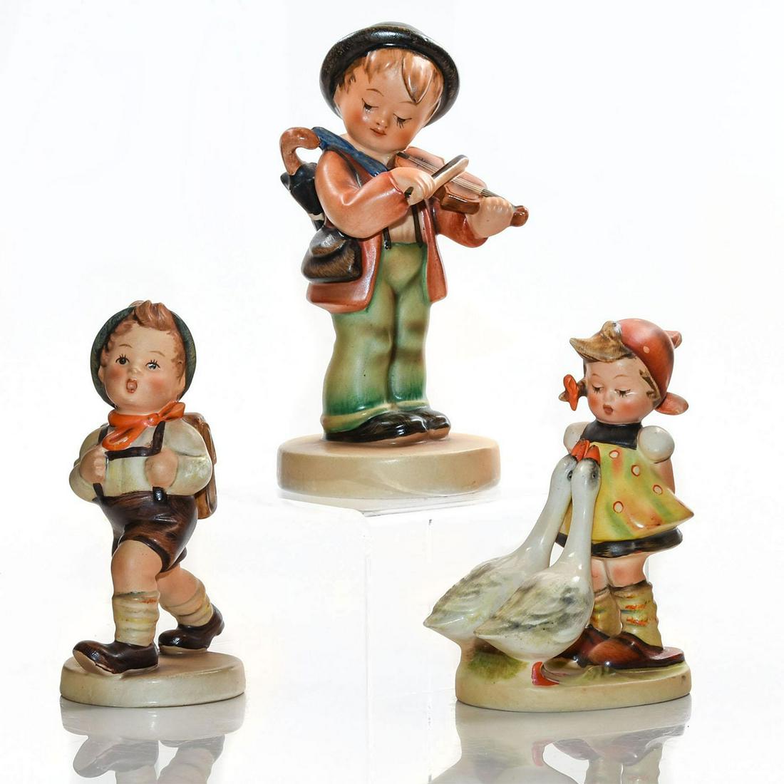 3 GOEBEL HUMMEL FIGURINES, CHILDREN STUDIES: Goose Girl 47 3/0; School Boy 82 2/0; boy with violin. Have Goebel and Germany makers marks to bottom. Issued: Mid 20th c. Dimensions: 5.25"H, tallest Manufacturer: Goebel Country of Origin: Germany