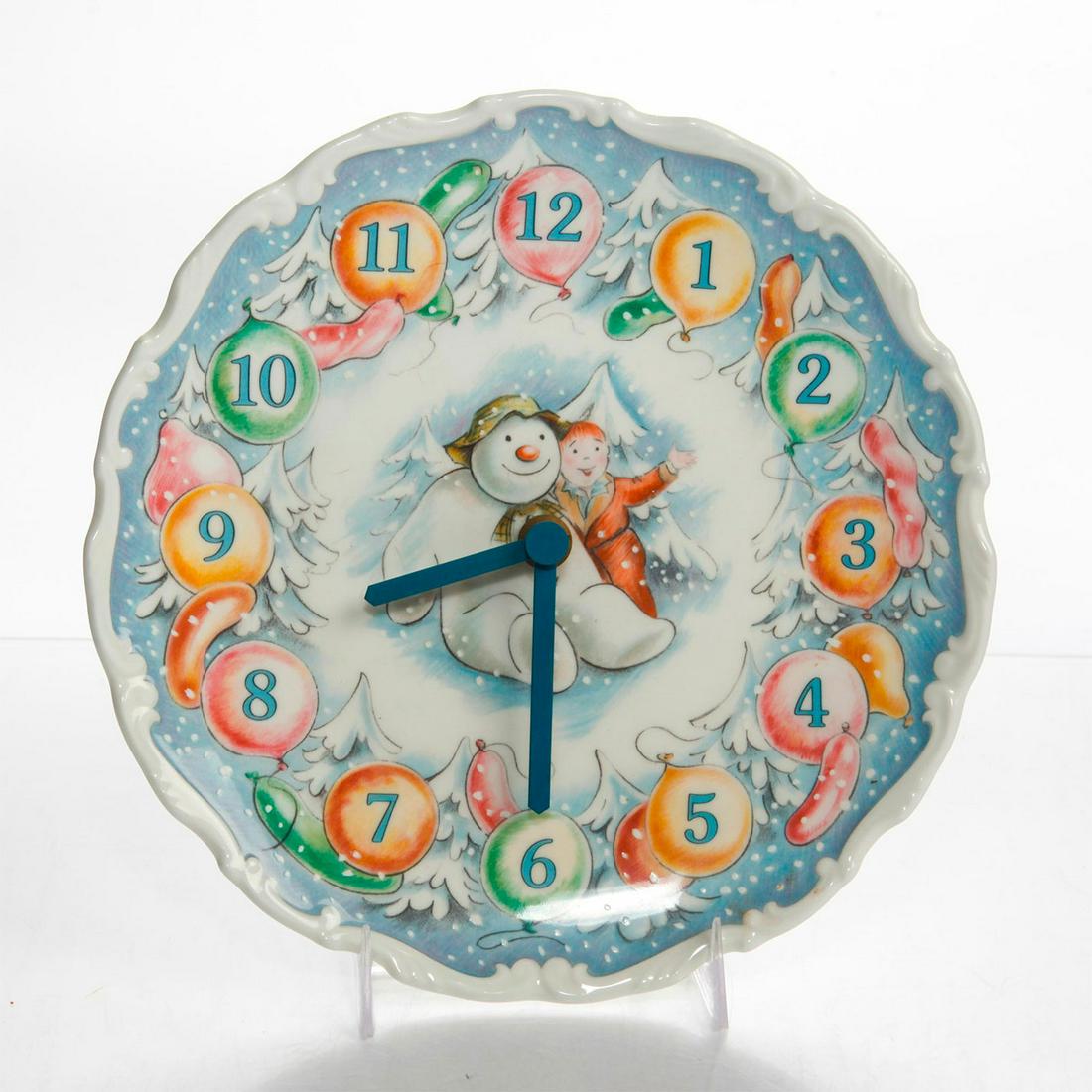 ROYAL DOULTON THE SNOWMAN GIFT COLLECTION WALL CLOCK: Ceramic clock depicts James and Snowman from film, The Snowman. Story was originally written by Raymond Briggs. Issued: 20th c. Dimensions: 8.5"D Manufacturer: Royal Doulton Country of Origin: England