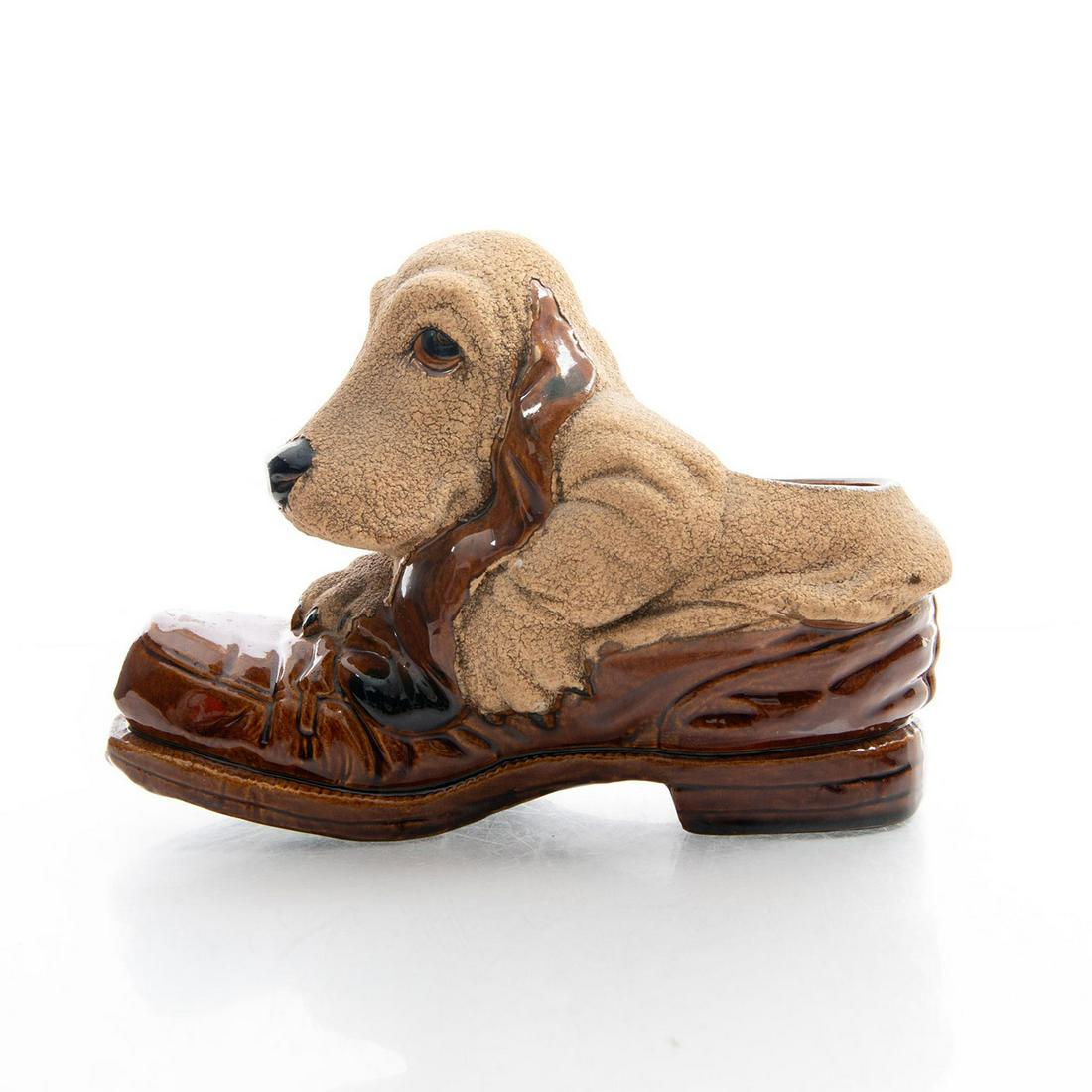 ROYAL HAEGER POTTERY HOUND DOG SHOE PLANTER: Long faced basset hound in a man's loafer. Haeger backstamp. Mid-century modern pottery from the iconic maker. Matte and glazed finish. Use related wear. Issued: 20th c. Dimensions: 7.75"H x 11"W Manu