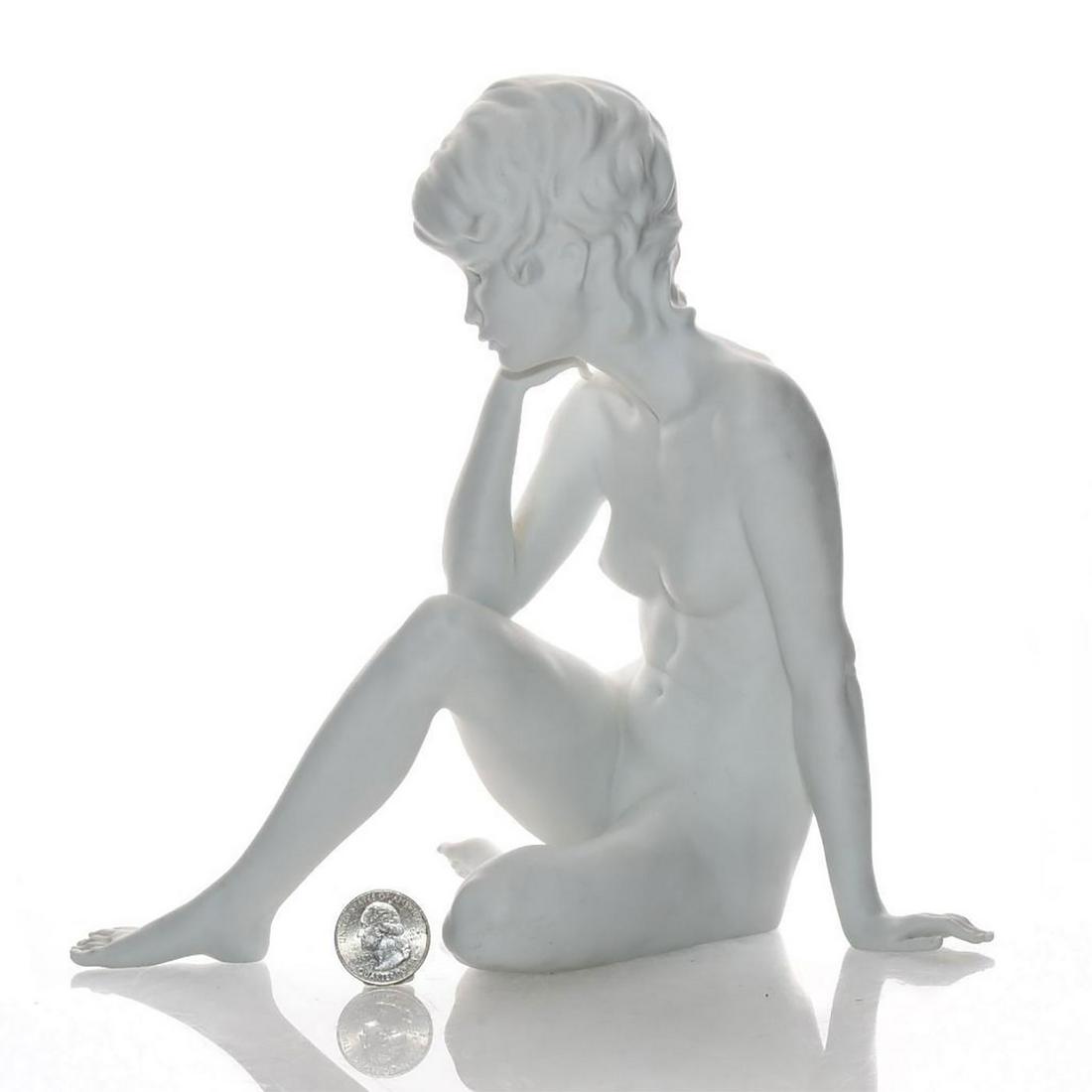 KAISER PORCELAIN FIGURINE, SEATED NUDE WOMAN: White porcelain; matte. Seated nude woman entranced in thought. Signed by artist on the underside. Kaiser backstamp. Issued: 20th c. Dimensions: 9.25"H Manufacturer: Kaiser Country of Origin: West Ger