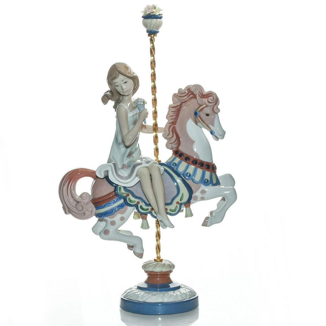 LARGE LLADRO FIGURINE, GIRL ON CAROUSEL HORSE 01001469: Features girl at a fair. Fine porcelain; glazed finish. Pink, white and blue colorway. Item number inscribed in base. Includes original box. Artist: Jose Puche Issued: 1985-2000 Dimensions: 15"H, figu