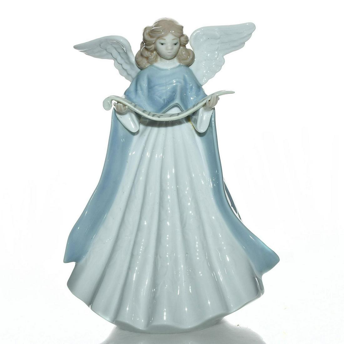 LLADRO ANGEL TREE TOPPER FIGURE , BLUE: Features an angel Christmas singer. Porcelain; glazed. Lladro stamp on the underside. Artist: Francisco Catala Issued: 1990 Dimensions: 7"H Manufacturer: Lladro Country of Origin: Spain