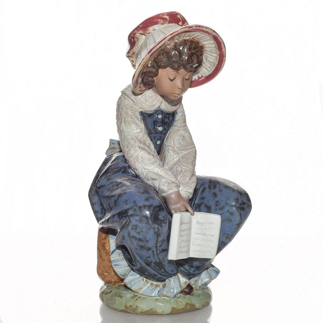 LLADRO FIGURINE, DOZING 01002155: Girl dozing with book in hand. Stoneware; gres or matte finish. Lladro stamp on the underside. Artist: Salvador Debon Issued: 1985-1989 Dimensions: 8.25"H Manufacturer: Lladro Country of Origin: Spain