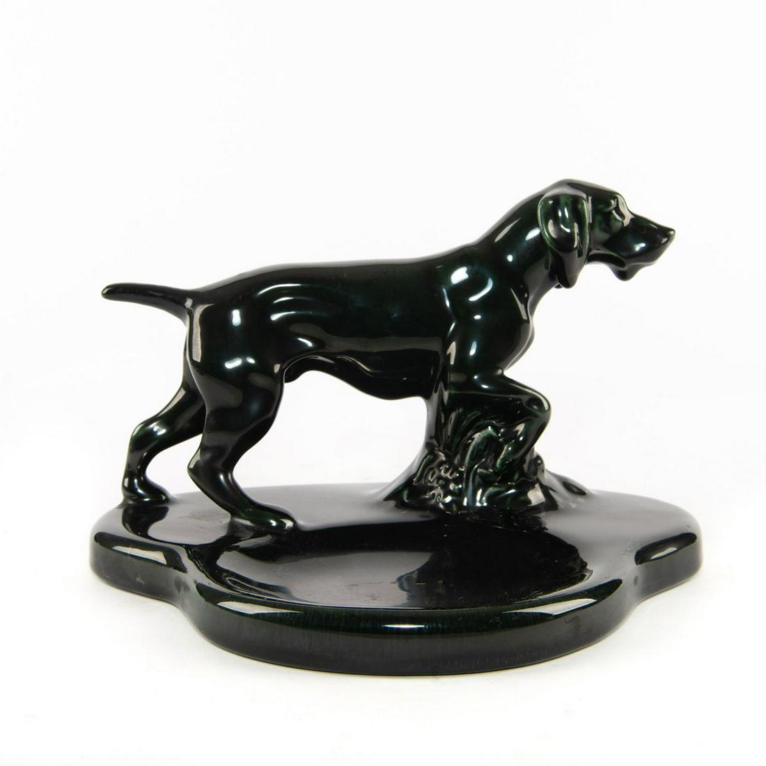 MOSAIC TILE COMPANY ENGLISH POINTER DOG DRESSER CADDY: Glazed ceramic, green and metallic lustre. Stamped to base. Modeled as an English Pointer standing in a thicket of flora with a heavy base. Produced with a rich, dark metallic green lustre glaze. Esta