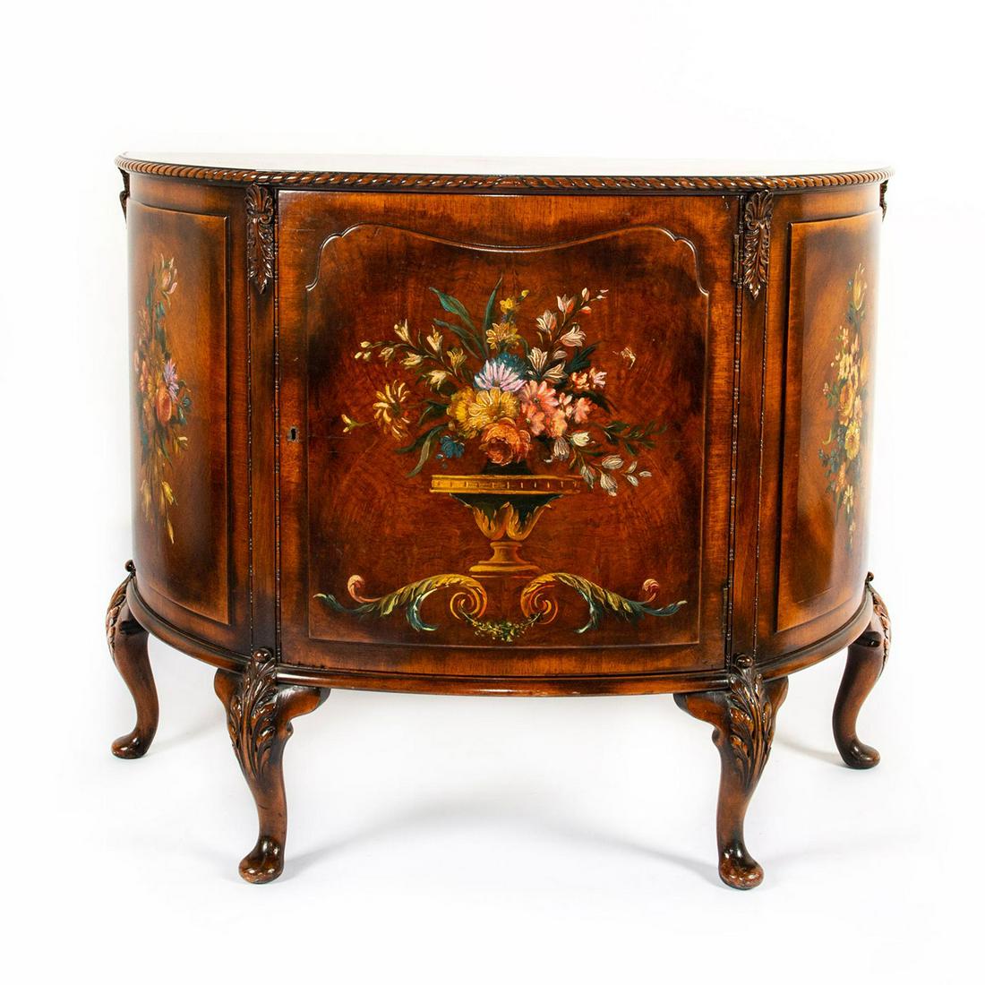 DEMILUNE COMMODE OR LIQUOR CABINET: Painted floral design to front, burl walnut top Age and use related wear. Missing key. Issued: 20th c. Dimensions: 40"L x 18.5"D x 32.5"H