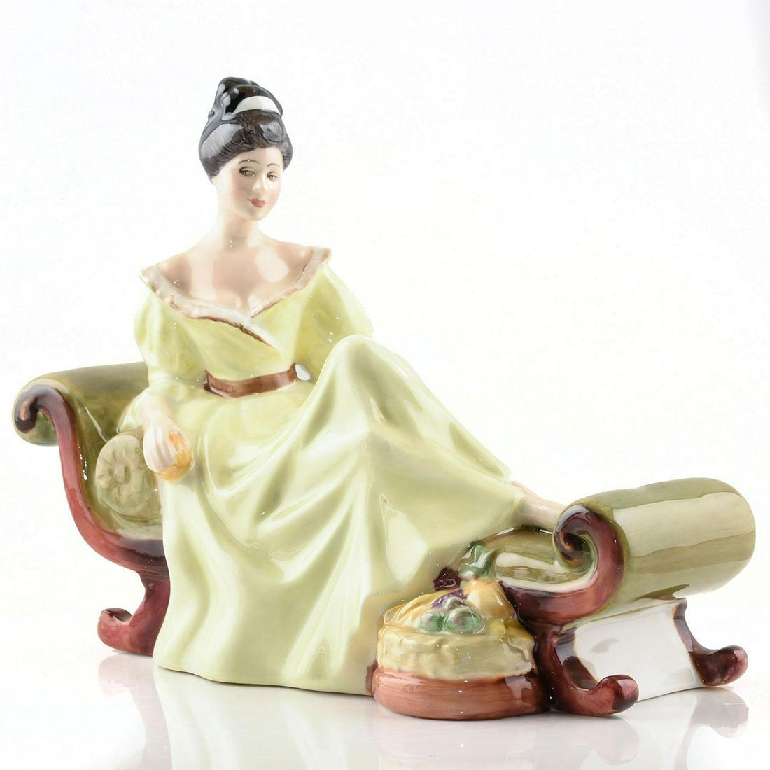 ROYAL DOULTON FIGURINE, AT EASE HN2473: Casually lounging on a lovely chaise, this pretty lady looks stunning in her yellow dress. Peggy Davies ClassicArtist: Peggy Davies Artist: Peggy Davies Issued: 1973 - 1979 Dimensions: 6"H Manufacture