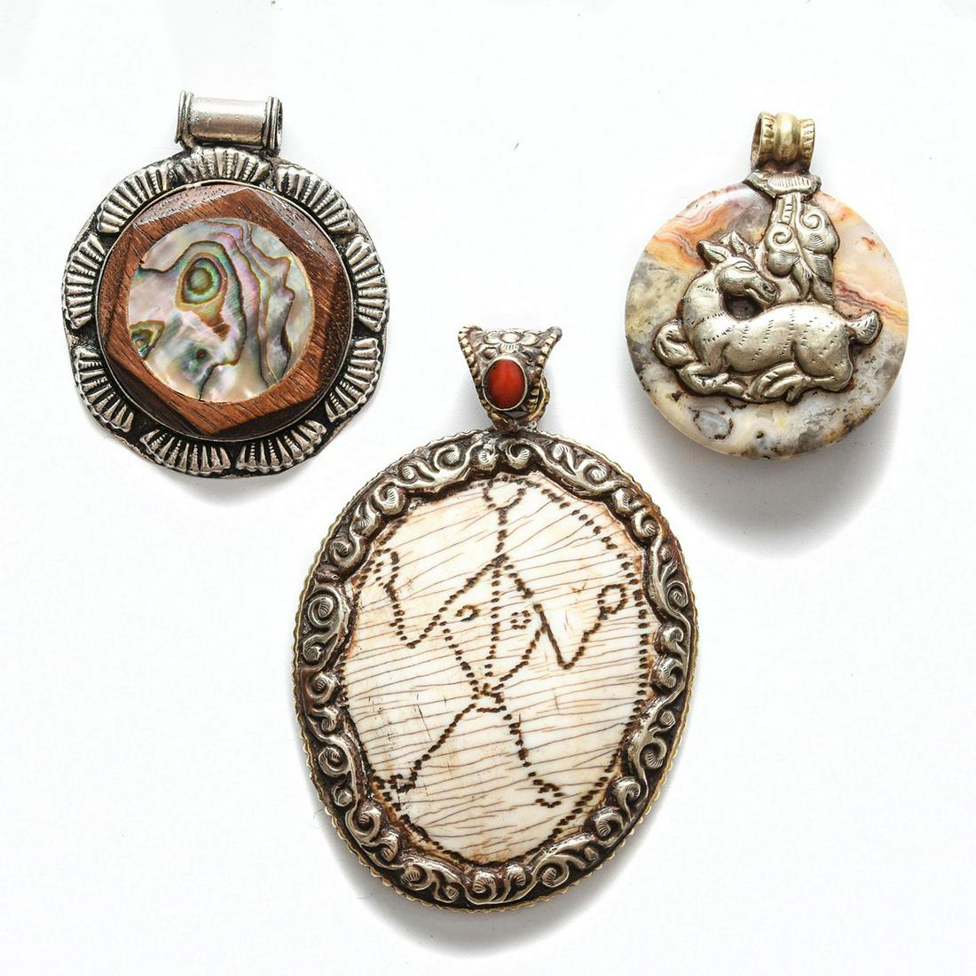 3 TIBET SILVER PENDANTS: Silver w. bone and red coral, stone, wood and shell. Total weight is approximately 83.6g. Issued: 20th c. Dimensions: 3.25"H, tallest Provenance: David Farin Collection