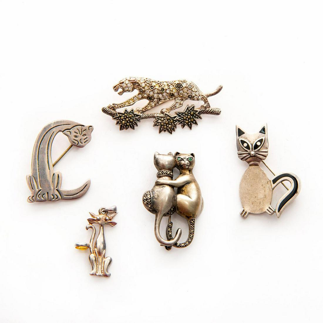 GROUP OF 5 925 SILVER PENDANT PINS, CAT THEMES: Includes embracing cats with emeralds, jungle cat with diamonds. Issued: c. 1980 Dimensions: 1.25"H x 2.5"W, largest Provenance: David Farin Collection