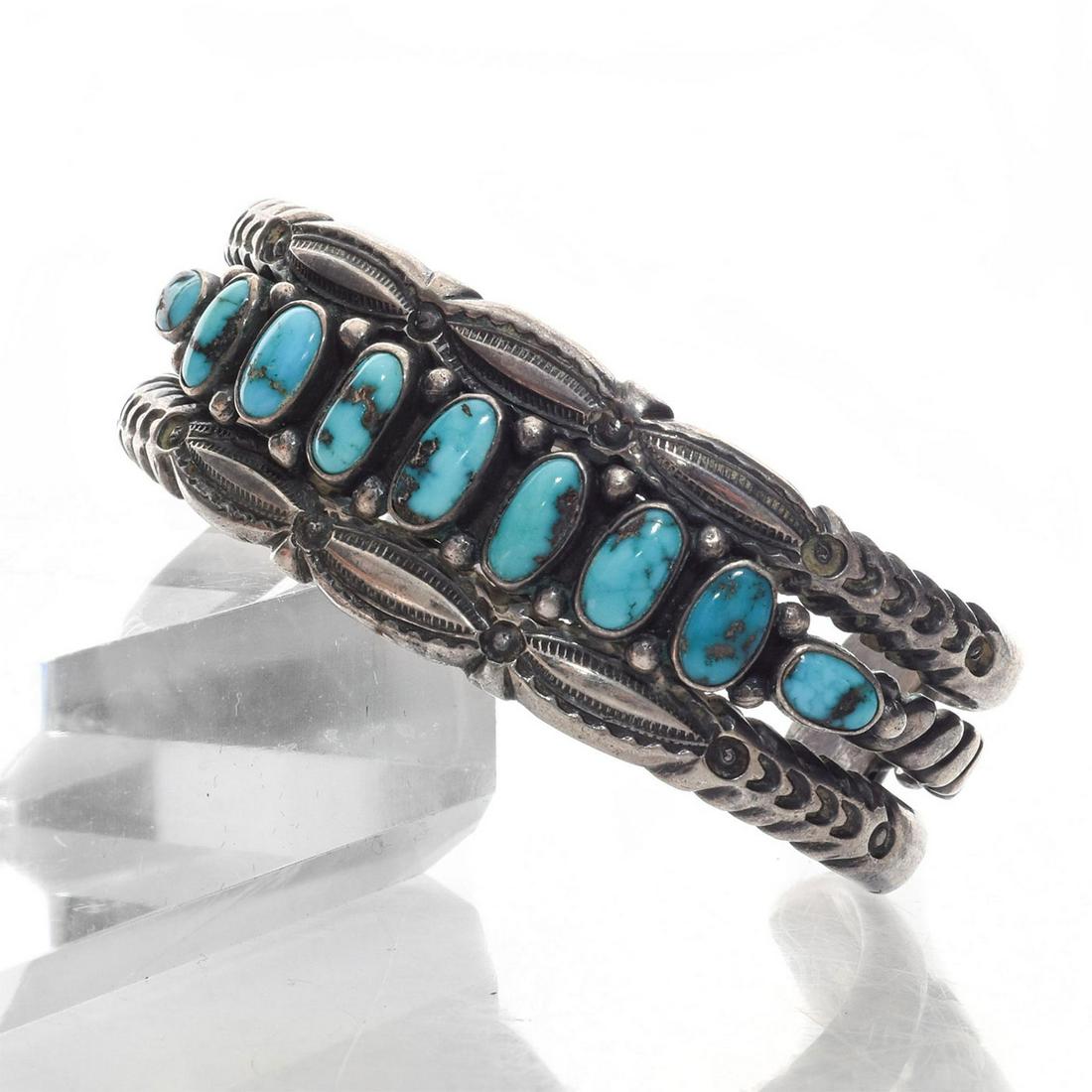 SILVER NAVAJO TRIBAL TURQUOISE CUFF BRACELET: Modeled with nine stones. Total approx. weight 65.5 grams. Issued: c. 1990 Dimensions: 2.25"D Country of Origin: United States Provenance: David Farin Collection