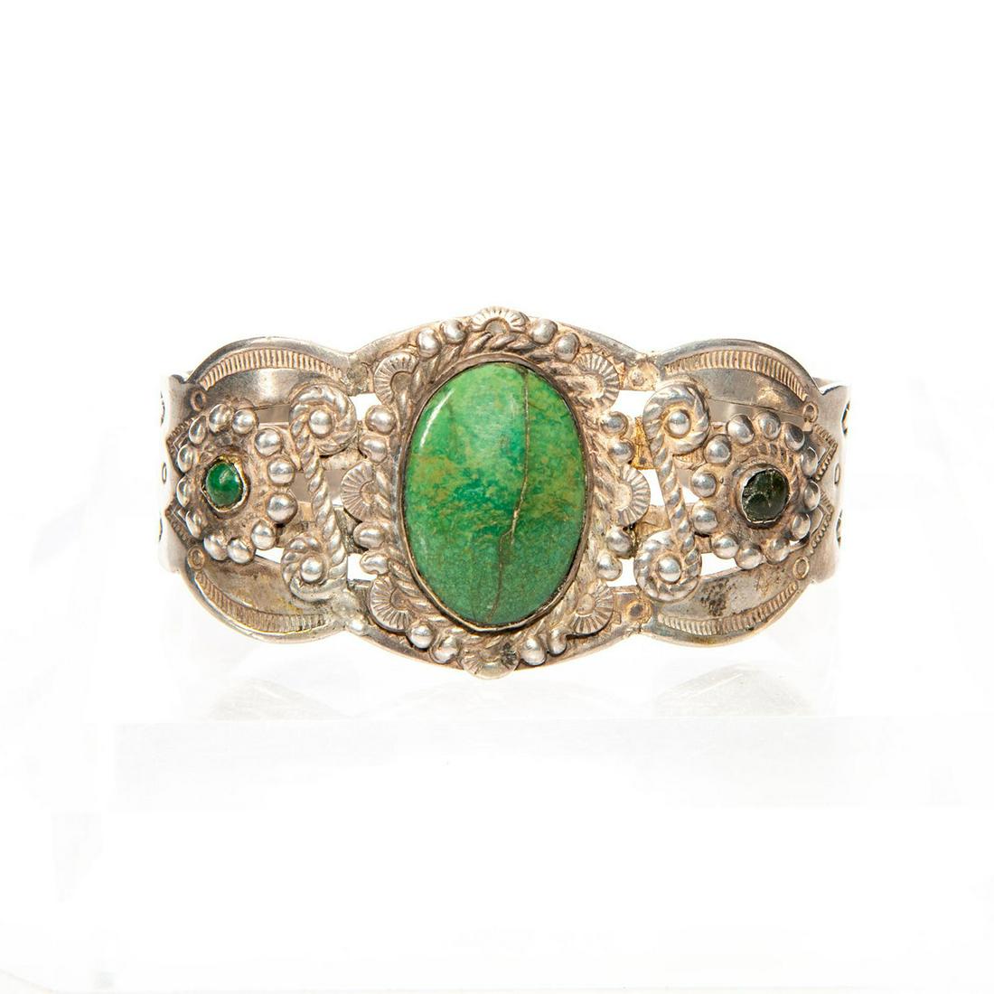 STERLING SILVER NAVAJO TRIBAL TURQUOISE CUFF BRACELET: 2 green turquoise stones, 1 damaged. Hallmarked. Approx. wt. 39g. Issued: c. 1995 Dimensions: 2.25"D Country of Origin: United States Provenance: David Farin Collection