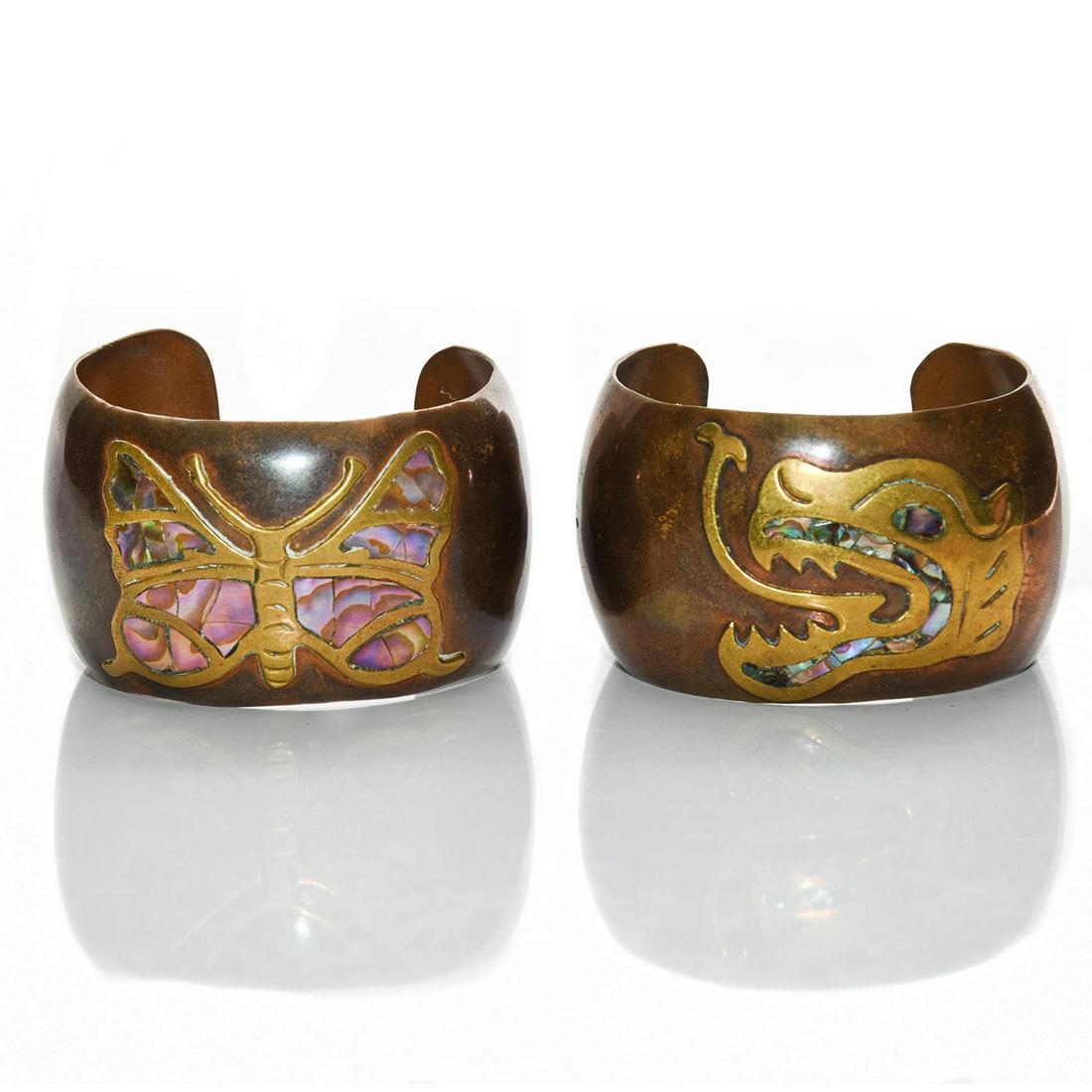 2 MEXICAN COPPER AND BRASS CUFF BRACELETS: Cuffs featuring a butterfly and dragon. Abalone shell inlay. 6"C. Pieces marked MEXICO on the underside. Issued: 20th c. Dimensions: 2.5"W Country of Origin: Mexico Provenance: David Farin Collection